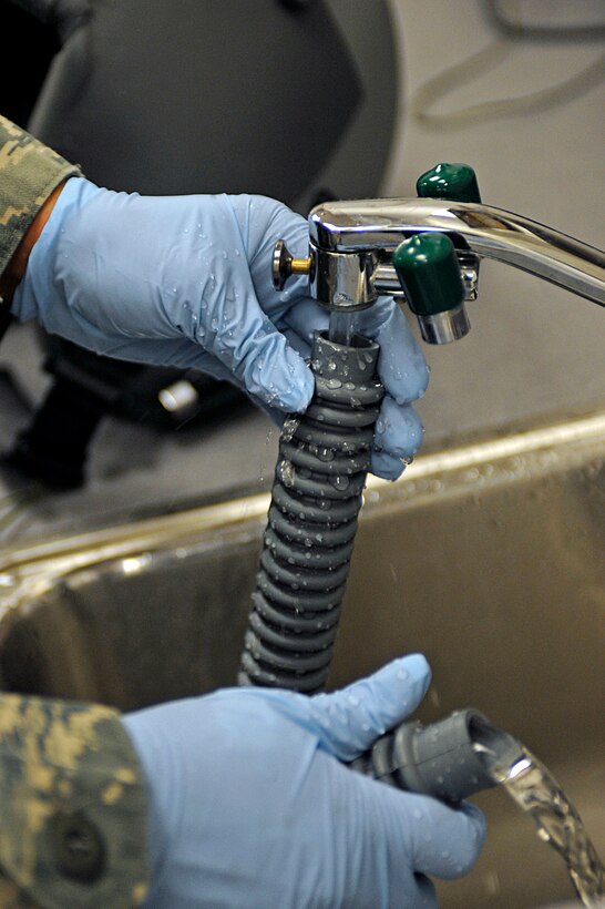 ELLSWORTH AIR FORCE BASE, S.D. -- Senior Airman Jennifer Lopez, 37th Bomb Squadron aircrew flight equipment technician, cleans an oxygen hose during a routine inspection of a flight helmet, March 22. Airman Lopez also inspects harnesses, vests and chemical bags for defects as part of her daily duties. (U.S. Air Force photo/Airman 1st Class Matthew Flynn)
