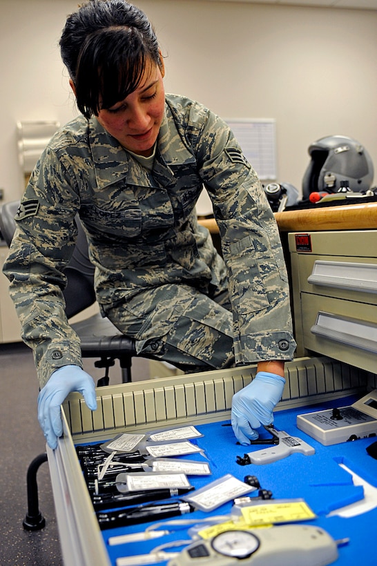 ELLSWORTH AIR FORCE BASE, S.D. -- Senior Airman Jennifer Lopez, 37th Bomb Squadron aircrew flight equipment technician, picks out a tool while inspecting flight helmets, March 22. Aircrew flight equipment personnel inspect all aircrew equipment and survival gear before it is used. (U.S. Air Force photo/Airman 1st Class Matthew Flynn)