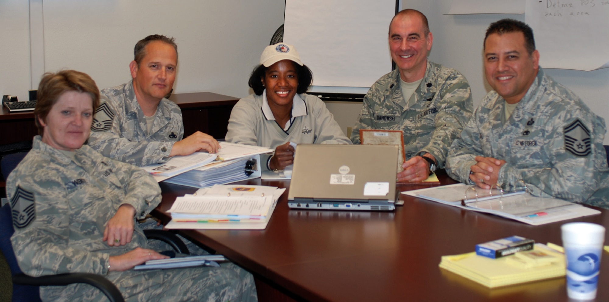 The five-member inspection team met to wade through some of the hefty binders pictured here. The team plans to meet on a weekly basis to ensure a smooth inspection process for the base. From left, Chief Master Sgt. Cheryl Wente, 452 MDG/SGA, Chief Master Sgt. Daniel Willers, 452 MXG/CCC, Lt. Col. Scipiaruth Kendall, 452 AMW/COO, Lt. Col. Raymond Danowski, 452 OG/CCE, and Senior Master Sgt. Mark Diaz, FSS/CCF. (U.S. Air Force photo by Megan Just)