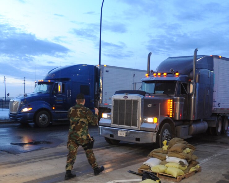 John Butz, Department of Defense Security supervisor, directs semi-trucks through the visitor gate March 18 on Grand Forks Air Force Base, N.D. The trucks were carrying supplies for the Federal Emergency Management Agency. Grand Forks AFB recently designated as an Incident Support Base for FEMA's flood relief efforts in the local area. (U.S. Air Force photo by Staff Sgt. Suellyn F. Nuckolls)