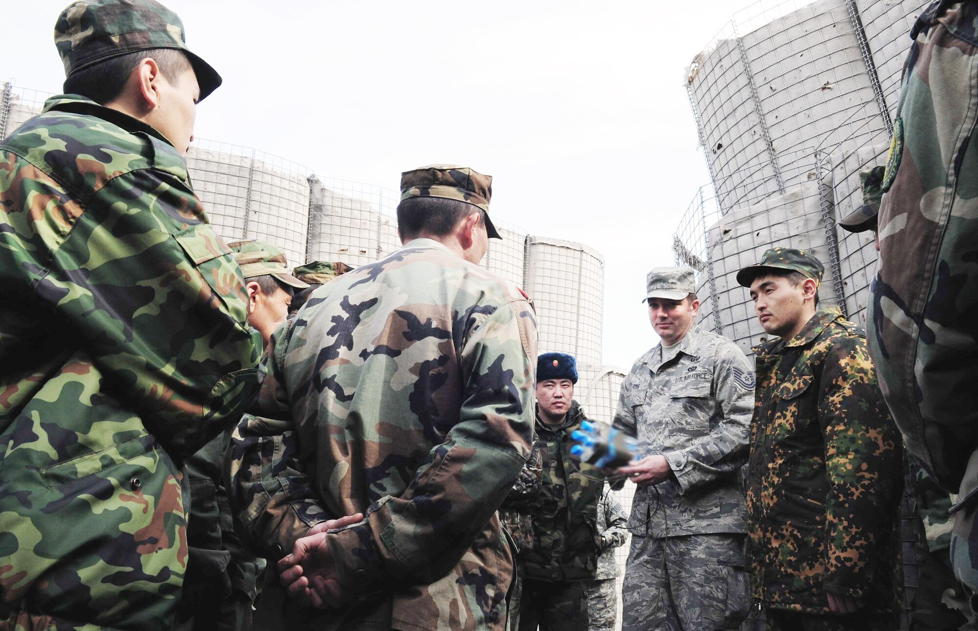 Tech. Sgt. Michael Yates discusses improvised water charges with Kyrgyz army explosive ordnance disposal technicians during a subject matter information exchange March 17, 2010, at the Transit Center at Manas, Kyrgyzstan. Sergeant Yates is the 376th Expeditionary Civil Engineer Squadron EOD Flight chief. (U.S. Air Force photo/Staff Sgt. Carolyn Viss)