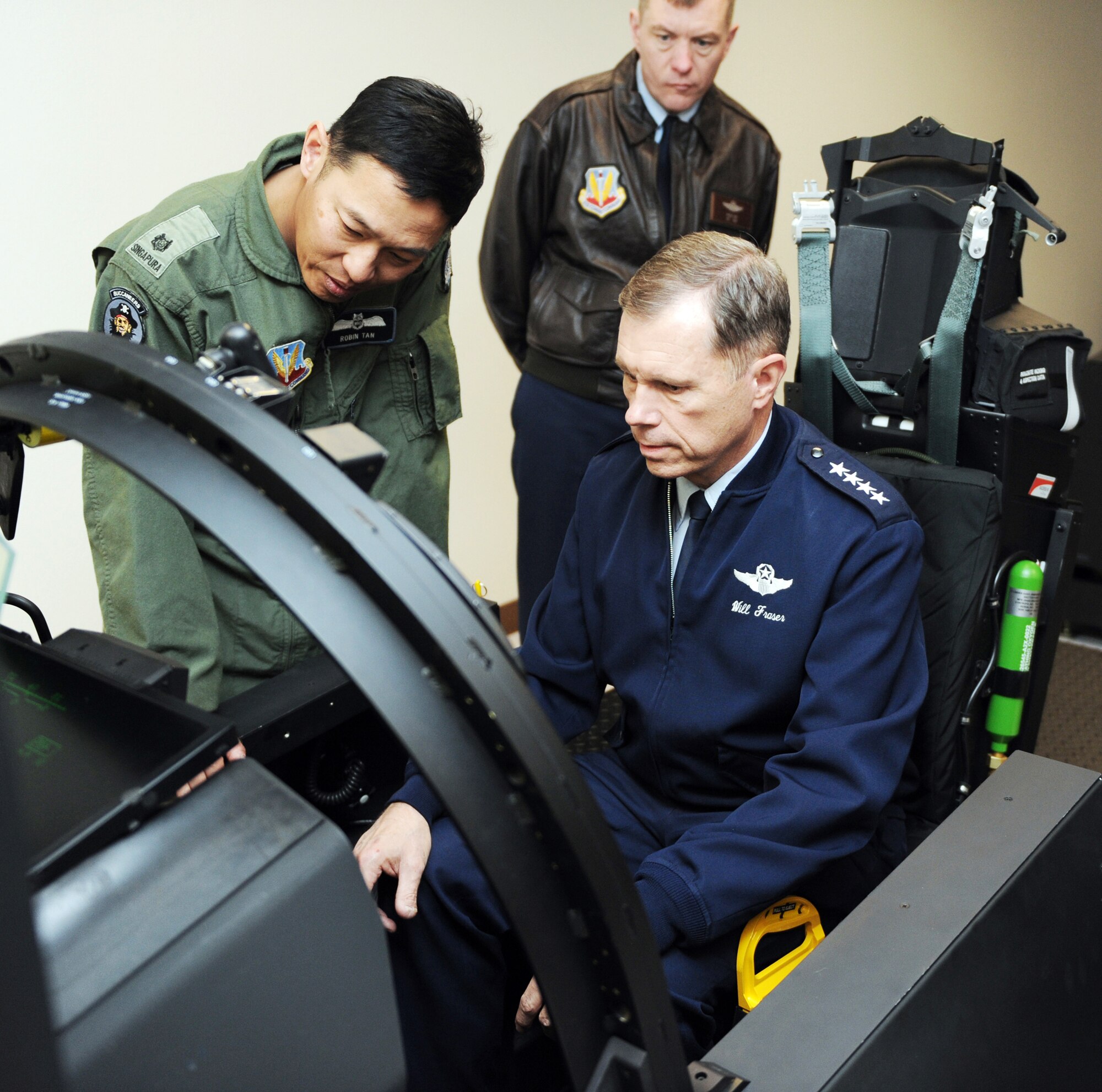Republic of Singapore Air Force Maj. Robin Tan shows Gen. William M. Fraser III the controls on the F-15SG flight simulator March 8, 2010, at Mountain Home Air Force Base, Idaho. The F-15SGs belong to the RSAF squadron stationed at Mountain Home AFB as part of the Peace Carvin V agreement. General Fraser is the commander of Air Combat Command. (U.S. Air Force photo/Airman 1st Class Debbie Lockhart)