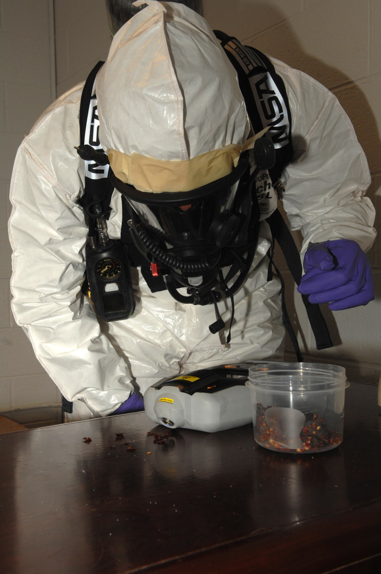 WHITEMAN AIR FORCE BASE, Mo., - Staff Sgt. Aaron Morris, 509th Civil Engineer Squadron Emergency Management technician, scoops up a sample of a simulated suspicious substance with an Ahura First Defender during a training exercise, here, March 19, 2010.  The Ahura is used to identify substances that may give investigators clues to what type of attack occurred or what terrorists may have been planning it.  Bioenvironmental members train often to maintain their accuracy and proficiency in their equipment and procedures in the event of an attack or mishap. (U.S. Air Force photo/Senior Airman Jessica Mae Snow)(Released)