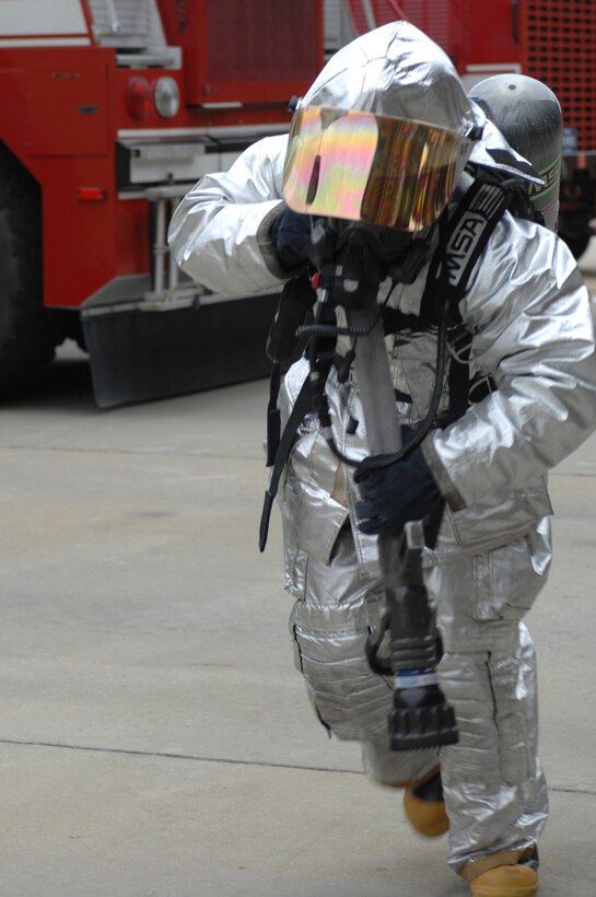 LANGLEY AIR FORCE BASE, Va. – Col. Wade Tolliver, 1st Fighter Wing vice commander, carries a fire hose during the second obstacle of a firefighter combat challenge test March 22.  The combat challenge test is an annual requirement for Langley firefighters. (U.S. Air Force photo/Tech. Sgt. April Wickes)