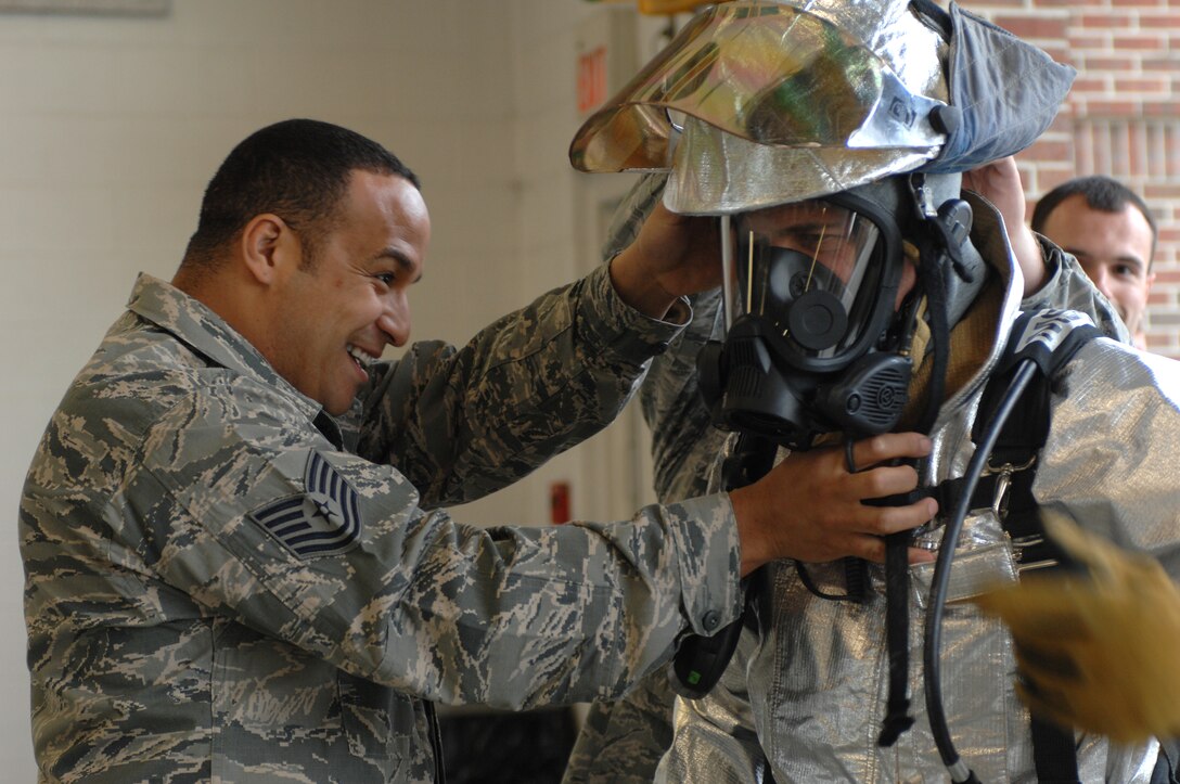 LANGLEY AIR FORCE BASE, Va. – Tech. Sgt. A.J. Eversley, 633d Civil Engineer Squadron station caption, helps Col. Matt Molloy, 1st Fighter Wing commander, don his fire protective equipment before a firefighter combat challenge test March 22.  Molloy finished the challenge in 7 minutes and 21 seconds. (U.S. Air Force photo/Tech. Sgt. April Wickes)