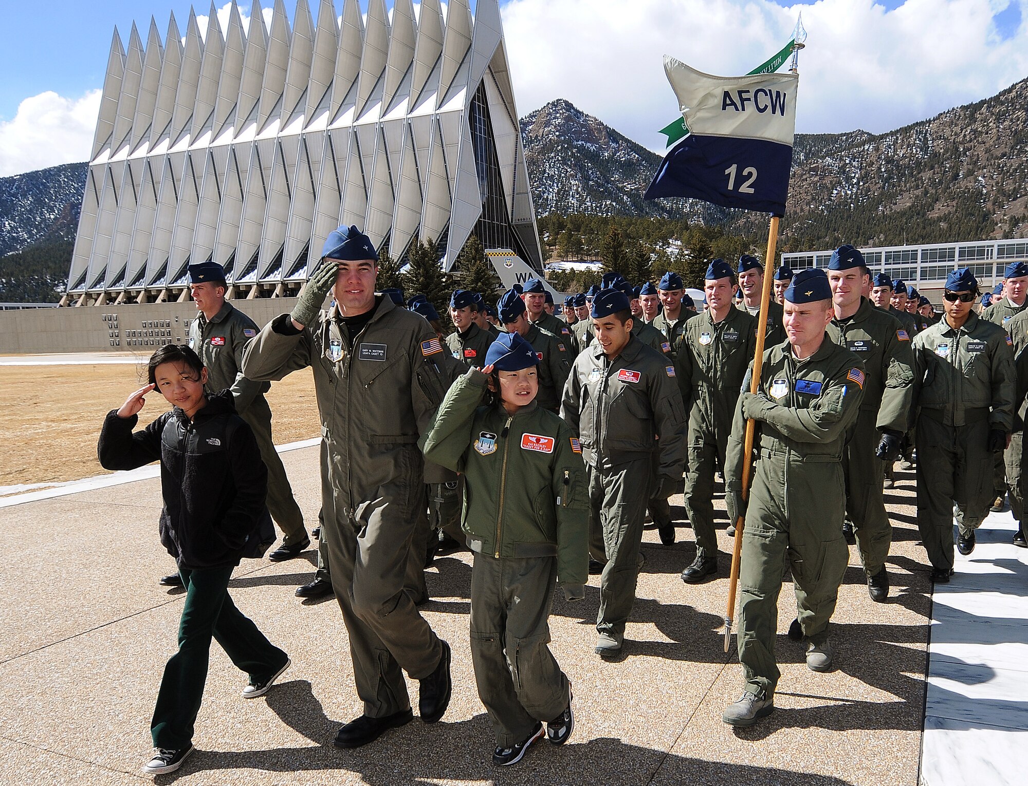 Lily Rackley, Cadet 1st Class Gary Whiteman and Cadet for a Day Kai Rackley salute during the noon meal formation at the Air Force Academy March 5, 2010. Other events during the Rackley family's visit included a tour of the Cadet Chapel and chemistry labs and a chance to try out flight simulators. Cadet Squadron 12 hosted the family for the two-day event. (U.S. Air Force photo/Rachel Boettcher)