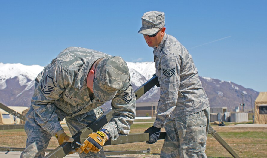 Master Sgt. David Berg and Staff Sgt. Steve Browning, 419th Civil Engineer Squadron, assemble the frame of a tent that will be used during Hill Air Force Base’s Operational Readiness Exercise, which began March 22. (U.S. Air Force photo/Staff Sgt. Alan Schultz)