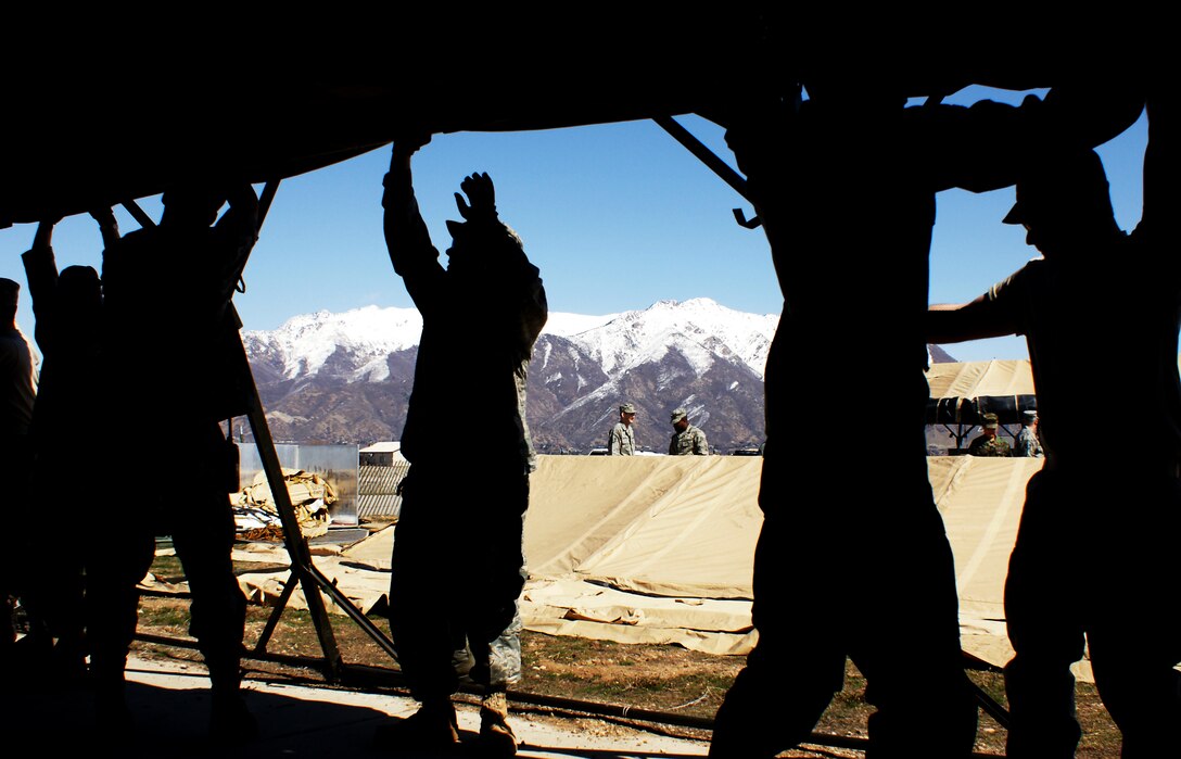 Members of the 419th Medical Squadron lift the weight of a tent as its supports are secured. The tents will be used during Hill Air Force Base’s Operational Readiness Exercise that began March 22. (U.S. Air Force photo/Staff Sgt. Alan Schultz)