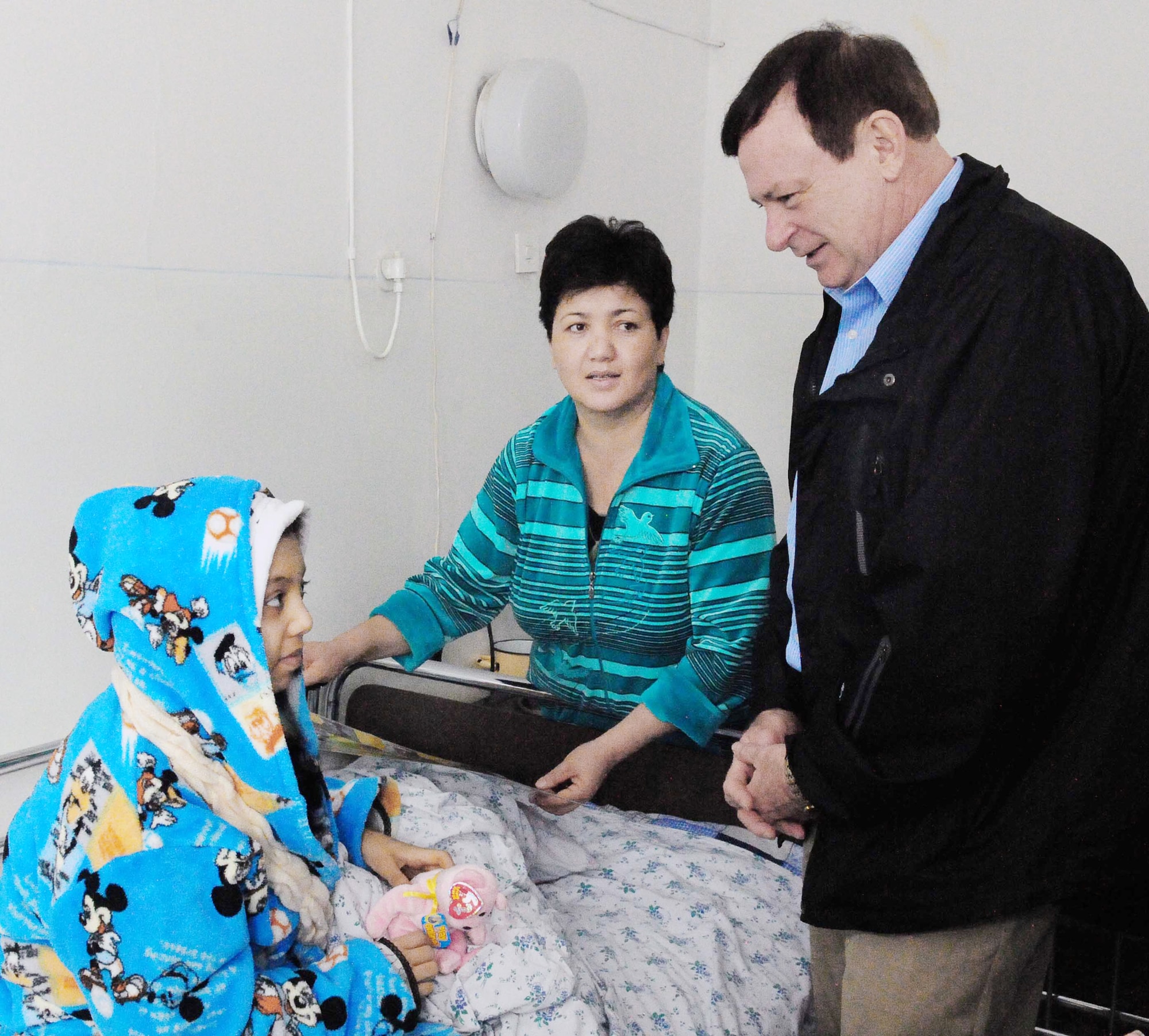 Chaplain (Lt. Col.) James Kinsey, the 376th Air Expeditionary Wing head chaplain at the Transit Center at Manas, Kyrgyzstan, speaks to Firuza Nurahunova as her mother, Polak, looks on.  Firuza, a 13-year-old Kyrgyz girl, just had open heart surgery March 21, 2010, at a hospital in Bishkek, Kyrgyzstan, to repair a faulty valve. This is Firuza's third heart surgery, and it was funded by Airmen in the Manas Area Benefits Outreach Society at the transit center.  MABOS is a non-profit organization on this installation that has now funded 150 open heart surgeries totaling more than $75,000 through private donations from Airmen and other caring Americans. (U.S. Air Force photo/Staff Sgt. Carolyn Viss)