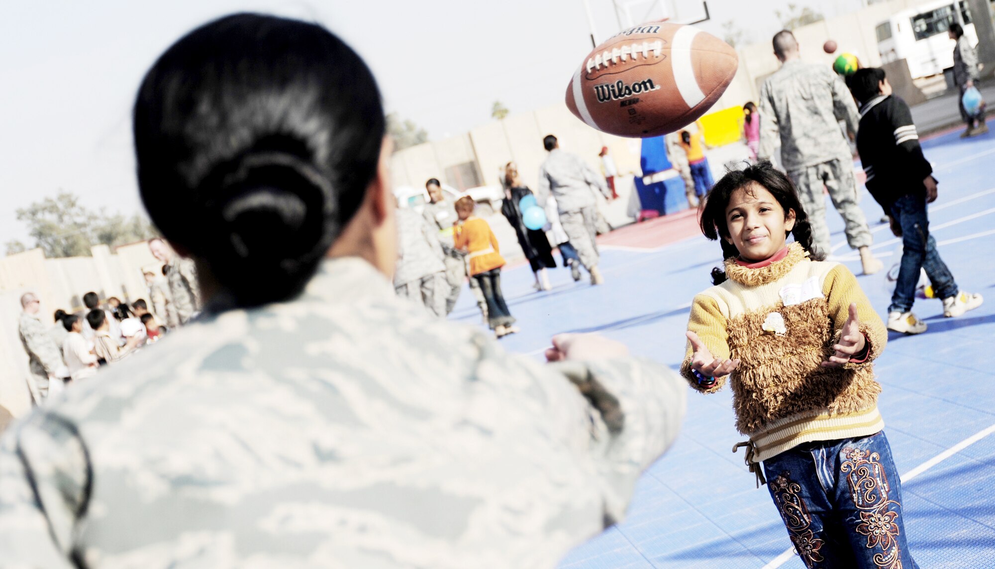 Airman 1st Class Valika Lagimaina plays with an Iraqi child during Iraqi Kids Day at the H-6 recreation area Dec. 19, 2009, at Joint Base Balad, Iraq. Airman Lagimaina is assigned to the 332nd Expeditionary Logistics Readiness Squadron. (U.S. Air Force photo/Senior Airman Christopher Hubenthal)