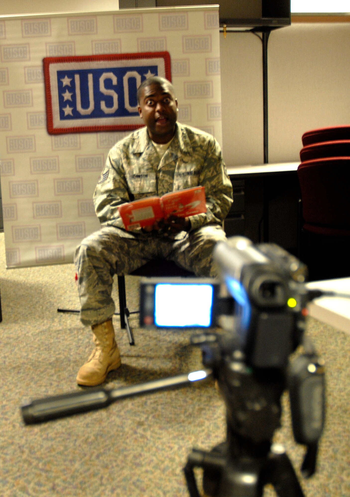 Staff Sgt. Jameson Thornton, 801st Special Operations Aircraft Maintenance Squadron, records himself as he reads a book to his 2-year-old daughter, Vanessa, for the "United Through Reading" program offered by the USO.  The USO will send the book and the DVD to the sergeant's family during his deployment, which will help keep the bond between parent and child strong. (U.S. Air Force photo by Staff Sgt. Stacy Fowler)