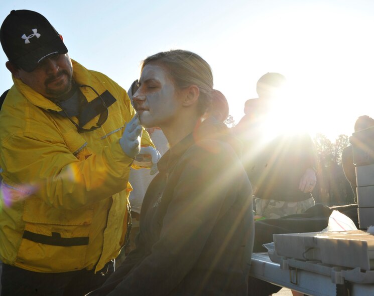 VALDOSTA, Ga. -- Staff Sgt. Heather Nealis, 823rd Security Forces Squadron fire team member, receives moulage from Mark Soliz, 23rd Medical Group emergency medical technician, to play a victim who has lost consciousness during a disaster drill at Wild Adventures Water and Theme Park here March 15. Military and family members from Moody Air Force Base, Ga., volunteered to play roles as park guests during the four-hour long exercise. Local ambulance and emergency room services, as well as several Lowndes County agencies, including the sheriff’s office, search and rescue team, and emergency dispatch were able to practice skills that might prove vital in a real-world scenario. (U.S. Air Force photo by Staff Sgt. Schelli Jones/Released)