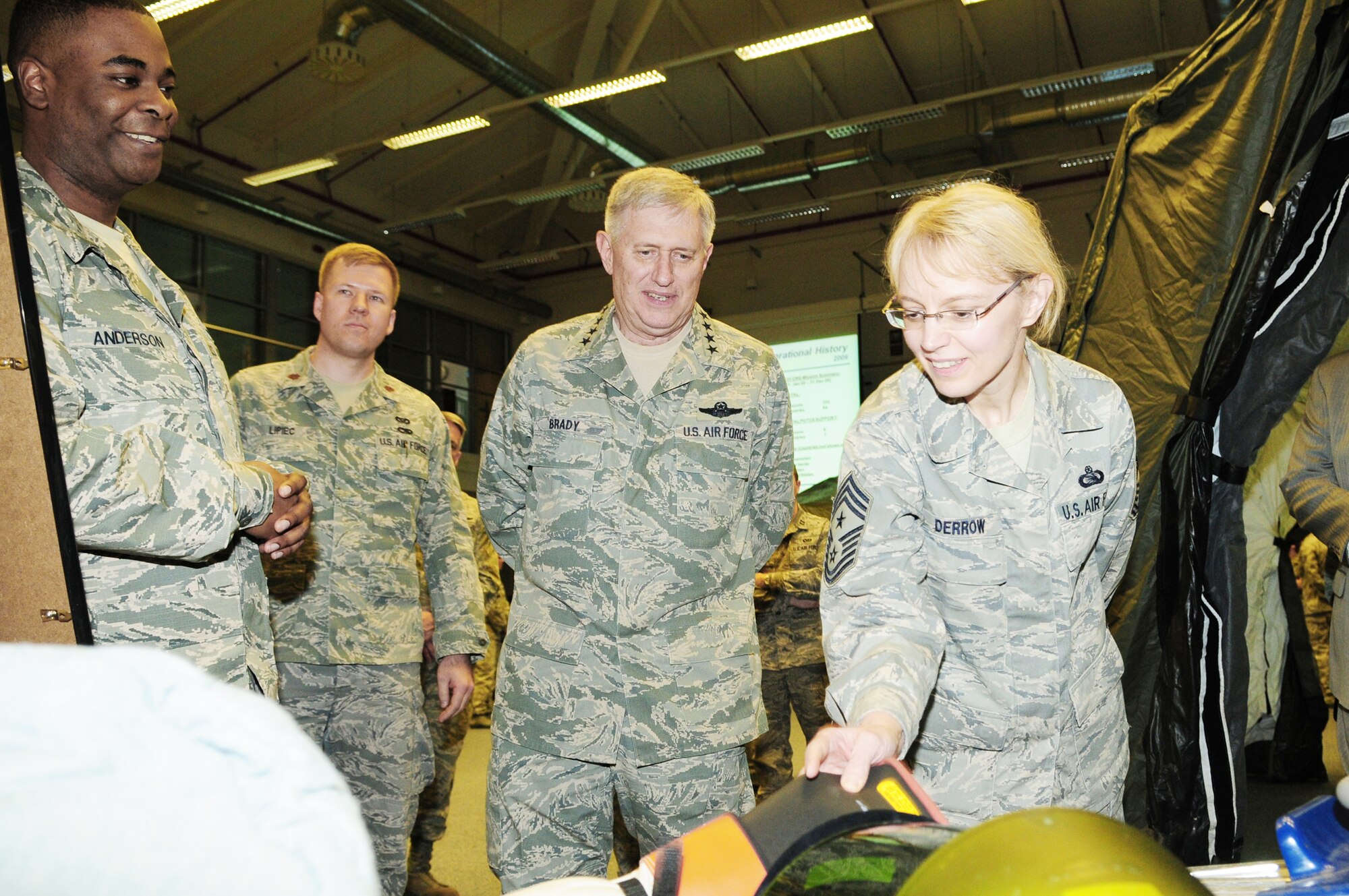 Gen. Roger A. Brady, U.S. Air Forces in Europe commander, and Chief Master Sgt. Pamela Derrow, USAFE command chief master sergeant, inspect personal protective equipment March 16, 2010, while Staff Sgt. Louis Anderson of the 435th Construction and Training Squadron explains how it is used.  General Brady and Chief Derrow spent the day visiting the facilities of the 435th Air Ground Operations Wing at Ramstein Air Base, Germany, their first visit to USAFE's newest wing since it stood up in July 2009. (U.S. Air Force photo/Airman Desiree Esposito)