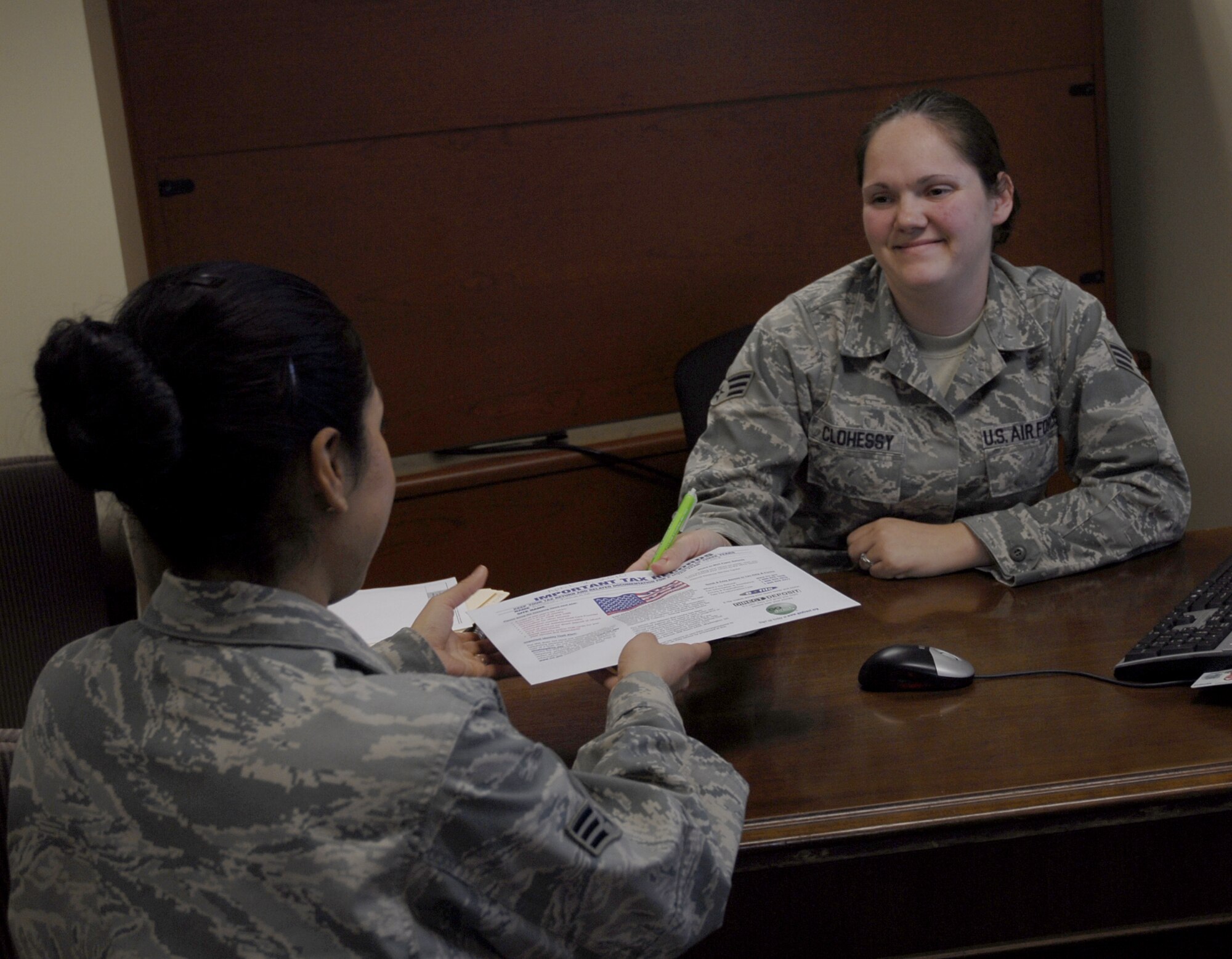Senior Airman Nichole Clohessy, 1st Special Operations Aircraft Maintenance Squadron, hands a completed tax return to Senior Airman Tomasita Wallace, 1st Special Operations Maintenance Group, at the Hurlburt Field Tax Office March 19. The Volunteer Income Tax Assistance program has been helping Airmen, retirees, civilians and their families get through the complexities of the filing process at no cost. (U.S. Air Force photo by Airman 1st Class Joe McFadden)