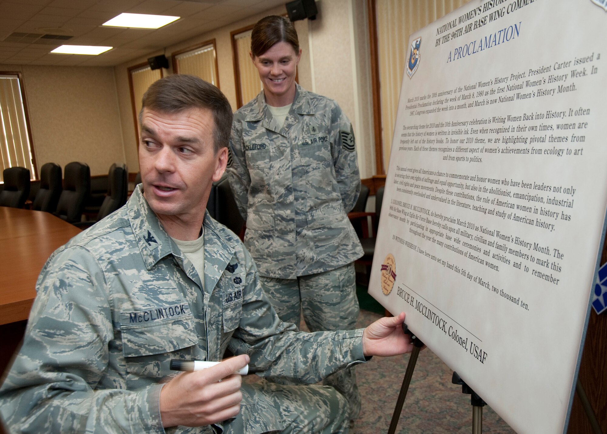 Col. Bruce McClintock, 96th Air Base Wing commander, signs a Women's History Month proclamation beginning the month of activities to inform the public on the historic efforts of women at Eglin Air Force Base, Fla.  (Courtesy photo.)