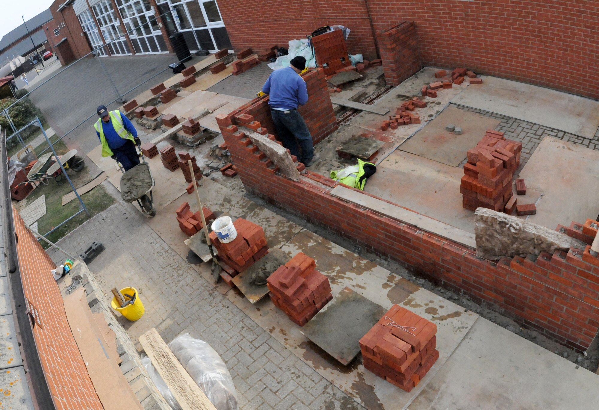RAF MILDENHALL, England – Jesse Foreman and Joe Hail, contracted mason workers, build the brick portion to the new conservatory and outside seating area at the Bob Hope Community Center March 18. This will provide base personnel an area to sit, relax and have access to the internet outside the building. (U.S. Air Force photo/ Staff Sgt. Jerry Fleshman)