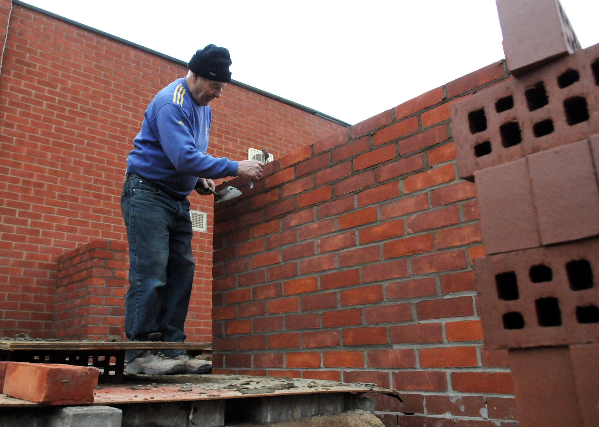 RAF MILDENHALL, England – Jesse Foreman, a contracted mason worker, finishes a brick wall of the new conservatory and outside seating area being built at the Bob Hope Community Center March 18. (U.S. Air Force photo/ Staff Sgt. Jerry Fleshman)