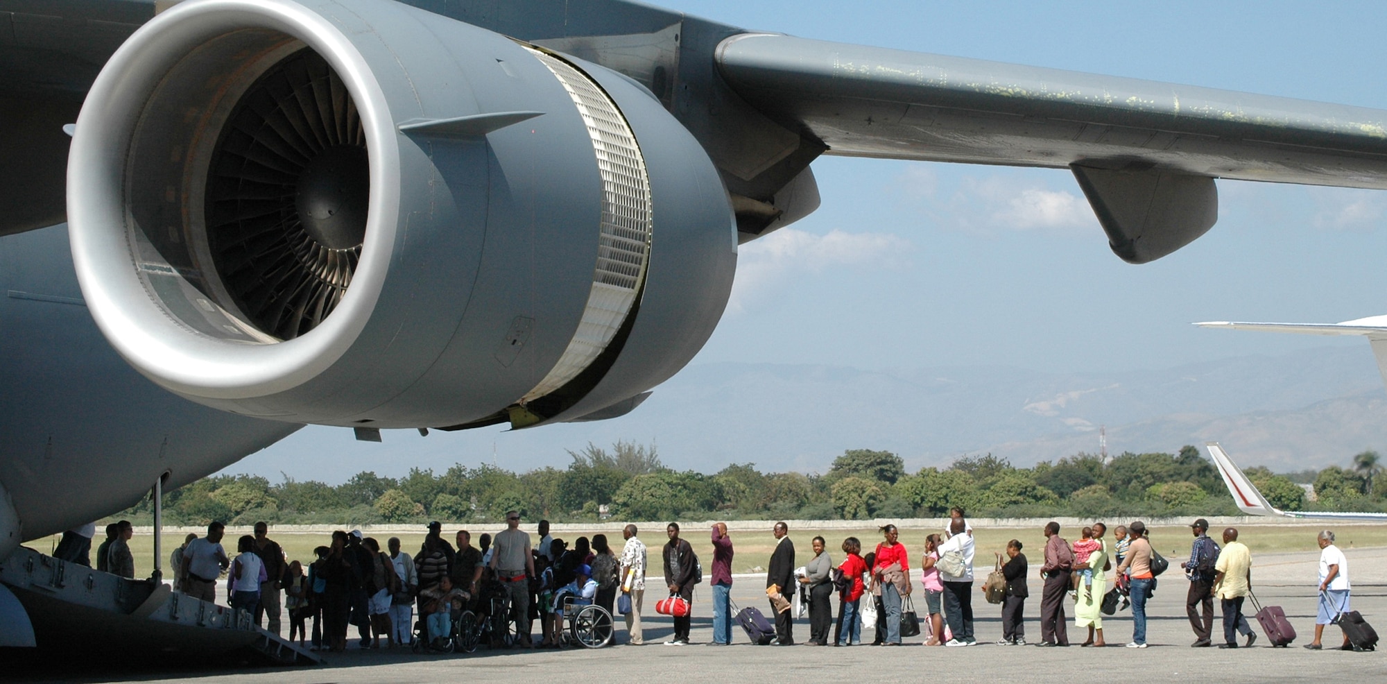 Airmen assigned to the 621st Contingency Response Wing from Joint Base McGuire-Dix-Lakehurst, N.J., assist in the loading of evacuees Jan. 23 at Toussaint L’Ouverture International Airport in Port-au-Prince, Haiti. The CRW immediately responded in the aftermath of a 7.0 magnitude earthquake that crumbled most of the surrounding area, killing hundreds of thousands and displacing millions from their homes. (U.S. Air Force photo /Tech. Sgt. Bryan Gatewood)