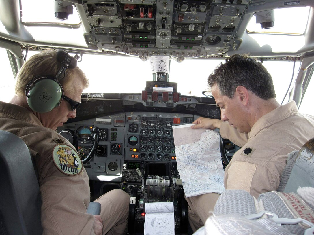 Two Georgia Air National Guard pilots from the 7th Expeditionary Airborne Command and Control Squadron review a National Geospatial-Intelligence Agency flight information publication prior to launching on a recent combat sortie in the U.S. Central Command area of responsibility. (Courtesy photo)