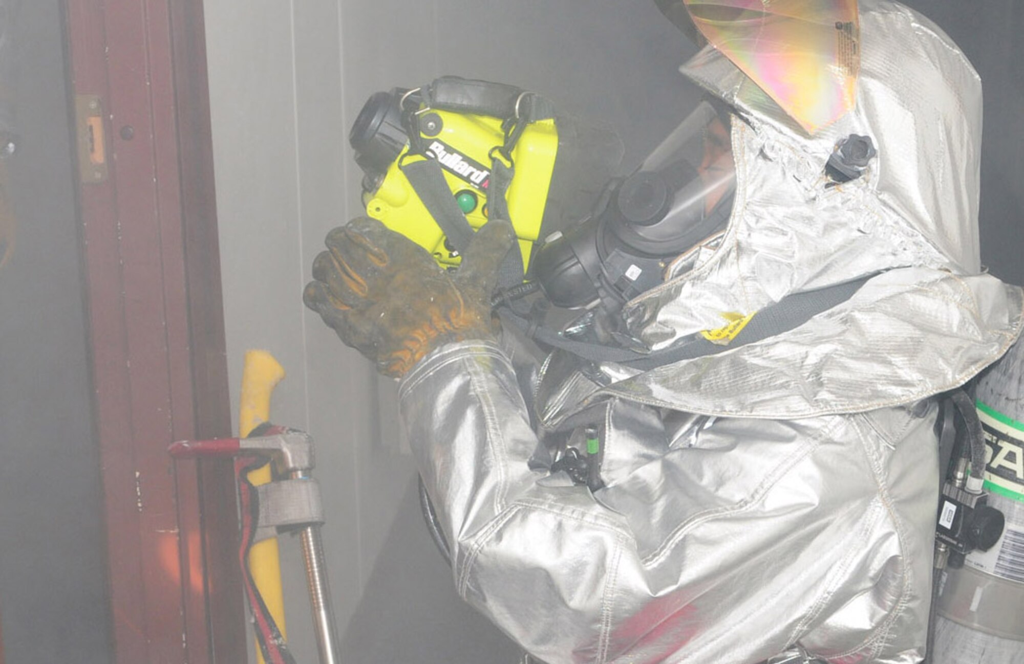 Tech. Sgt. Corey Coleman, 100th Civil Engineer Squadron Fire Department, uses a thermal imaging camera to see through smoke and check for casualties during an exercise in Building 804 March 18. The building was filled with smoke and firefighters responded by entering the building to check for casualties and making sure the building was safe.  (U.S. Air Force photo/Karen Abeyasekere)