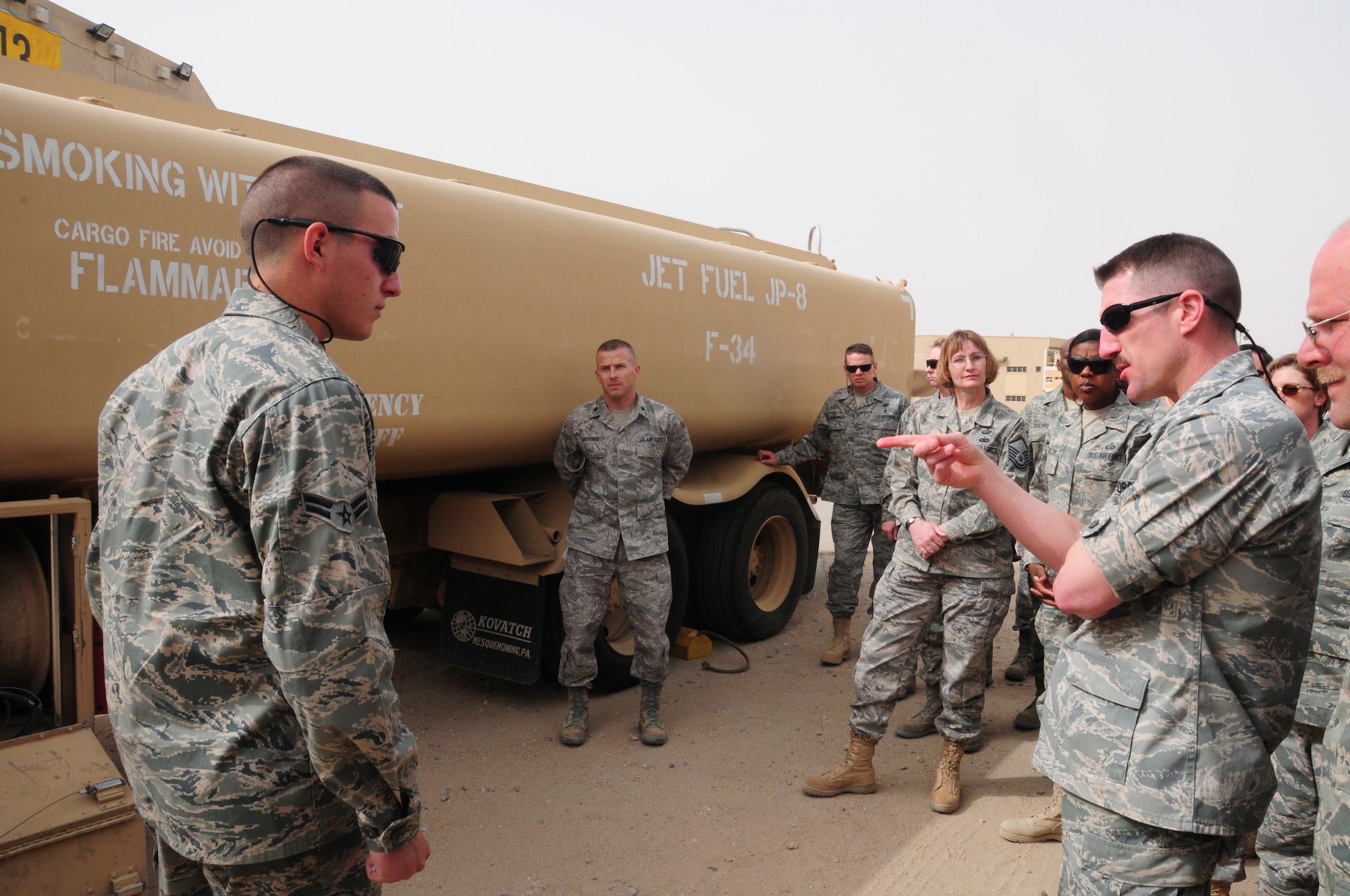 SOUTHWEST ASIA -- U.S. Air Force Maj. Robert McCabe, 386th Expeditionary Contracting Squadron commander, asks Airman 1st Class Colin Orr, 386th Expeditionary Logistics Readiness Squadron fuels distribution operator, a question about the nozzles of the hoses on one of the fuel trucks during an Open House March 21, 2010 hosted by the Fuels Management Flight here at an air base in Southwest Asia. Members of the 386th Air Expeditionary Wing ventured down to the flight line side of the base, known as “The Quarry”, to get a better understanding of the fuels process to include the offloading, receiving and transferring portions. (U.S. Air Force photo by Staff Sgt. Lakisha A. Croley/Released)