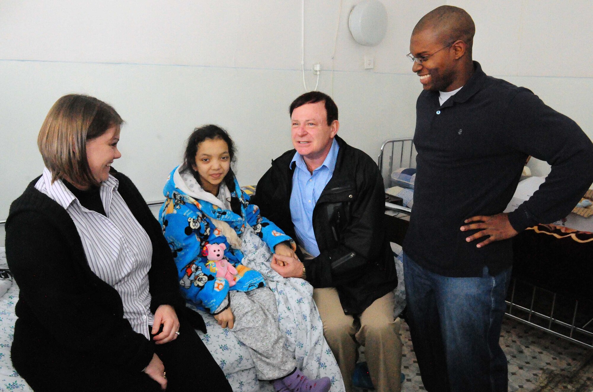 Staff Sgt. Crystal Myers, Ch. (Lt. Col.) James Kinsey, and Senior Airman Jonathan Blythe visit with Firuza Nurahunova, a 14-year-old Kyrgyz girl who just had open heart surgery to repair a faulty valve at a hospital in Bishkek, Kyrgyzstan, March 21, 2010. This is Firuza?s third heart surgery, and it was funded by the Manas Area Benefits Outreach Society at the Transit Center at Manas, Kyrgyzstan. MABOS is a non-profit organization on this installation that has now funded 150 open heart surgeries totaling more than $75,000 through private donations from Airmen and other caring Americans. (U.S. Air Force photo/Staff Sgt. Carolyn Viss/released)