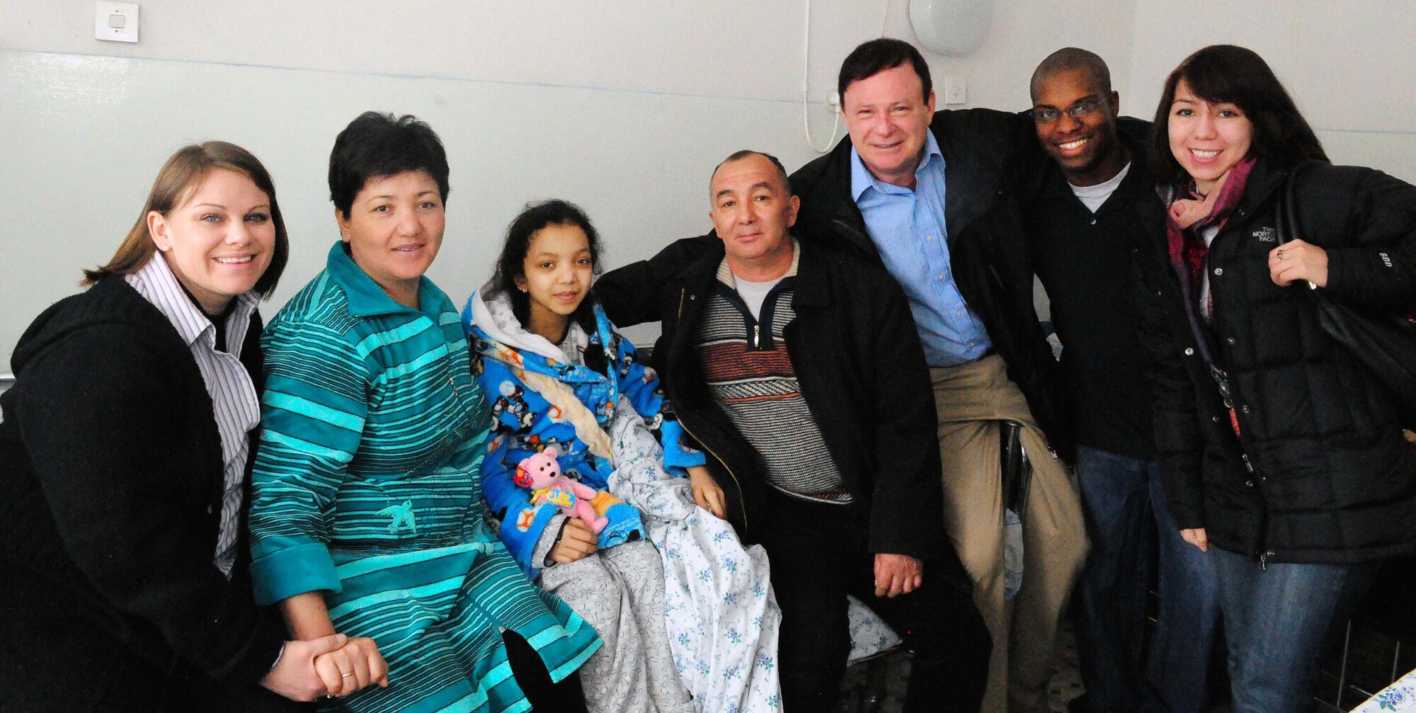 Airmen from the Transit Center at Manas pose for a photo with Firuza Nurahunova and her parents, Polak and Shakura Nurahunova, at a hospital in Bishkek, Kyrgyzstan, March 21, 2010. Firuza, 14, just had open heart surgery to repair a faulty valve. This is her third heart surgery, and it was funded by the Manas Area Benefits Outreach Society at the Transit Center at Manas, Kyrgyzstan. MABOS is a non-profit organization on this installation that has now funded 150 open heart surgeries totaling more than $75,000 through private donations from Airmen and other caring Americans. (U.S. Air Force photo/Staff Sgt. Carolyn Viss/released)