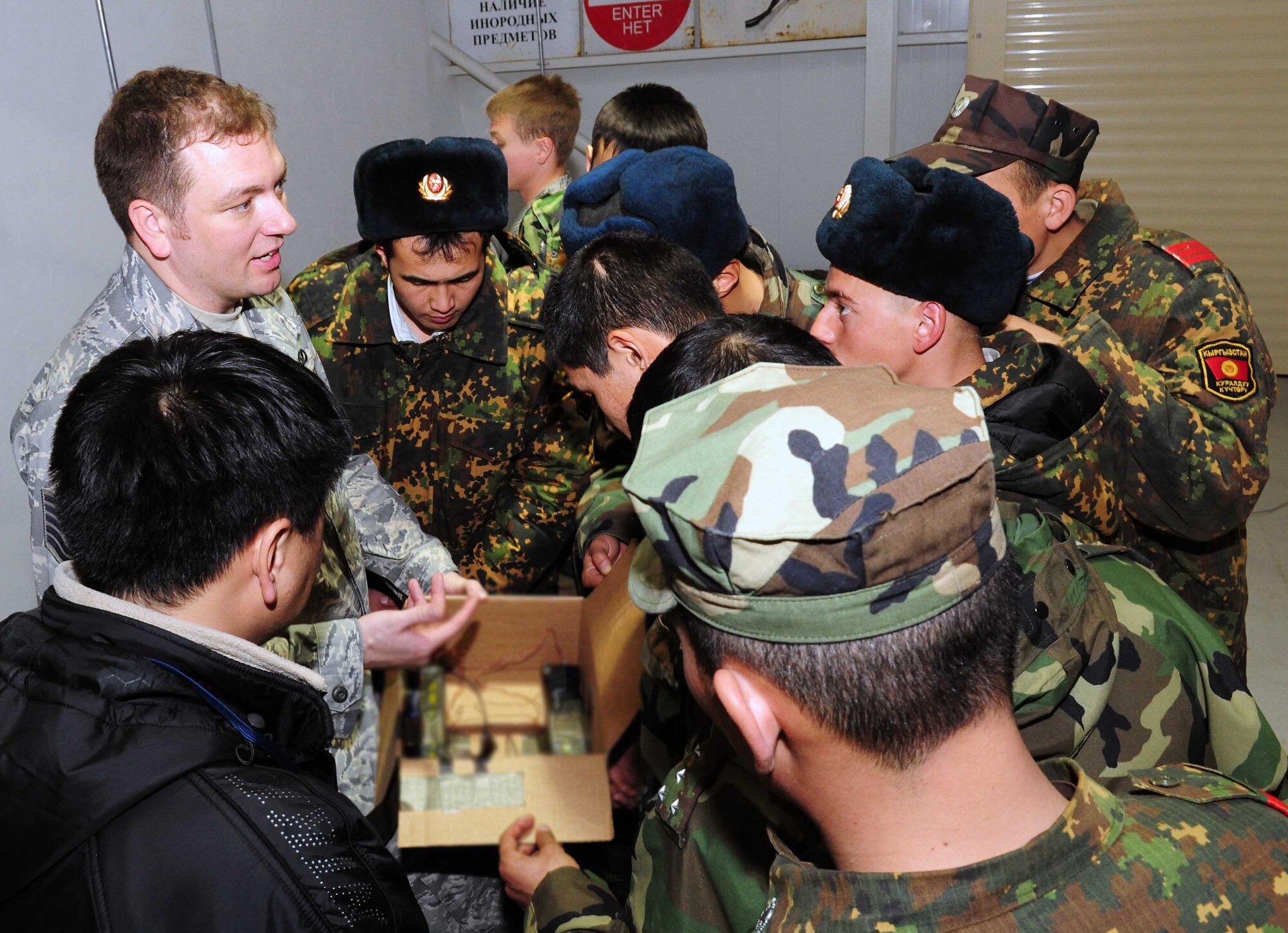U.S. Air Force Tech. Sgt. Michael Yates, 376th Expeditionary Civil Engineer Squadron explosive ordnance disposal flight chief, compares a simulated improvised explosive device to its x-ray with Kyrgyz army EOD techs during a subject matter information exchange March 16. (U.S. Air Force photo/Staff Sgt. Carolyn Viss/released) 