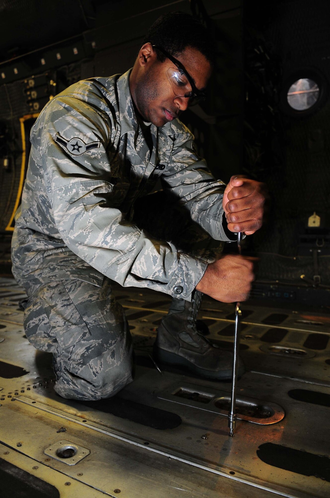 YOKOTA AIR BASE, Japan -- Airman Shannon Harris, 374th Maintenance Squadron crew chief, pulls up a floor panel from a MC-130 talon II March 16 during inspection. Each plane undergoes an isochronal inspection which consists of a 14-day detailed inspection before the plane is ready for re-launch. (U.S. Air Force photo/Airman 1st Class Devin Doskey)