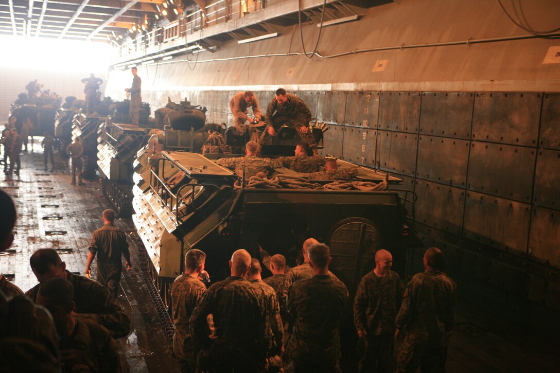Marines with Battalion Landing Team 2nd Battalion, 7th Marines (BLT 2/7), 31st Marine Expeditionary Unit (MEU), await to mount amphibious assault vehicles (AAV) to take part in a simulated mechanized raid aboard the forward-deployed amphibious assault ship USS Essex (LHD 2), March 23. The MEU conducted a tactical offload consisting of a mechanized raid, boat raid, helicopter raid and a humanitarian assistance and disaster relief (HA/DR) exercise. This is the first time that the MEU conducted  a tactical offload in Okinawa, Japan. (Official Marine Corps photo by Lance Cpl. Dengrier M. Baez)