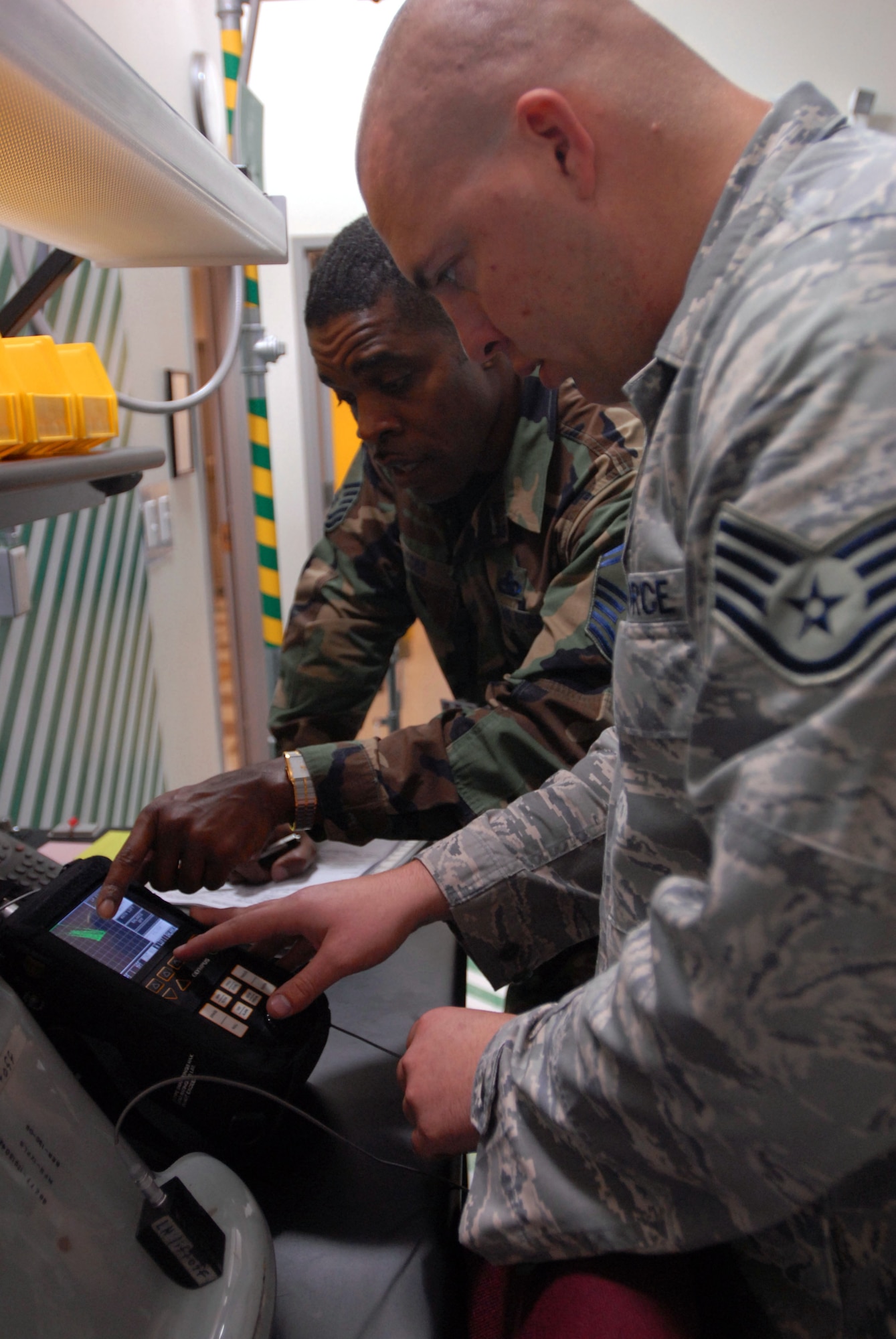 JOINT BASE PEARL HARBOR HICKAM, Hawaii – Senior Master Sgt. William Cobb, Headquarters Air Mobility Command, Scott Air Force Base (IL), inspects Staff Sgt. Daniel Fletcher, 15th Maintenance Squadron, during the Logistics Compliance Assessment Program inspection here, March 23. The LCAP is conducted every two years and provides leadership at all levels with an evaluation of a unit's ability to perform key logistics processes in a safe, standardized, repeatable and technically compliant manner. (U.S. Air Force photo/Senior Airman Gustavo Gonzalez)