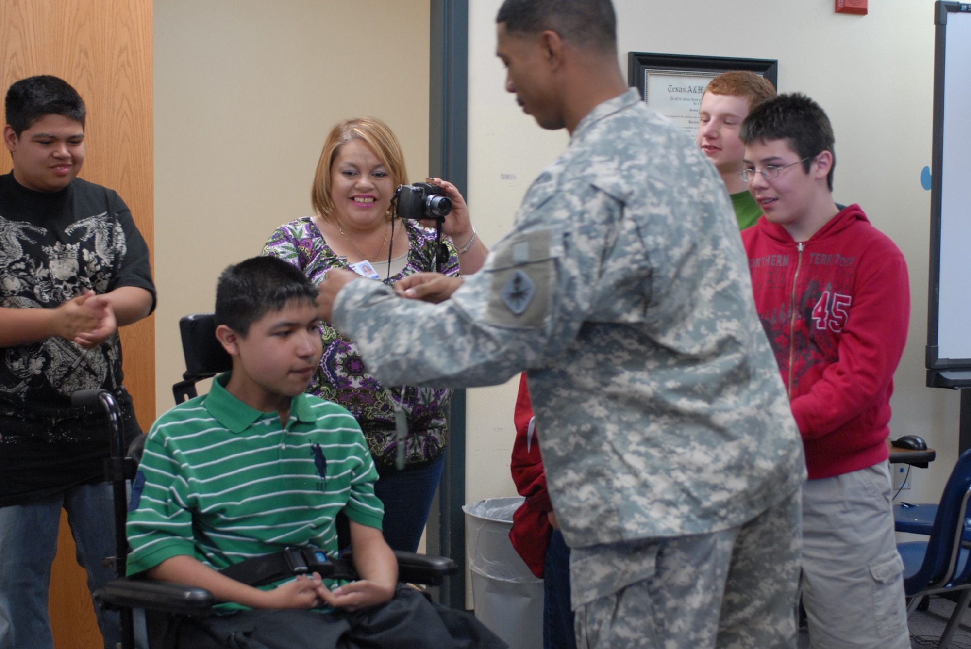 SAN ANGELO, Texas -- Army Sgt. 1st Class Jason Payne presents Javier Aguirre with his own set of military dog tags at Lincoln Junior High School, March 23, 2010. Javier has Duchere Muscular Dystrophy and expressed a wish, through the Make-A-Wish Foundation, to meet with U.S. Army Soldiers. Sgt 1st Class Payne and fellow Soldiers from the 344th Military Intelligence Battalion, Goodfellow Air Force Base, answered the call. (U.S. Air Force photo/Staff Sgt. Laura R. McFarlane)  

