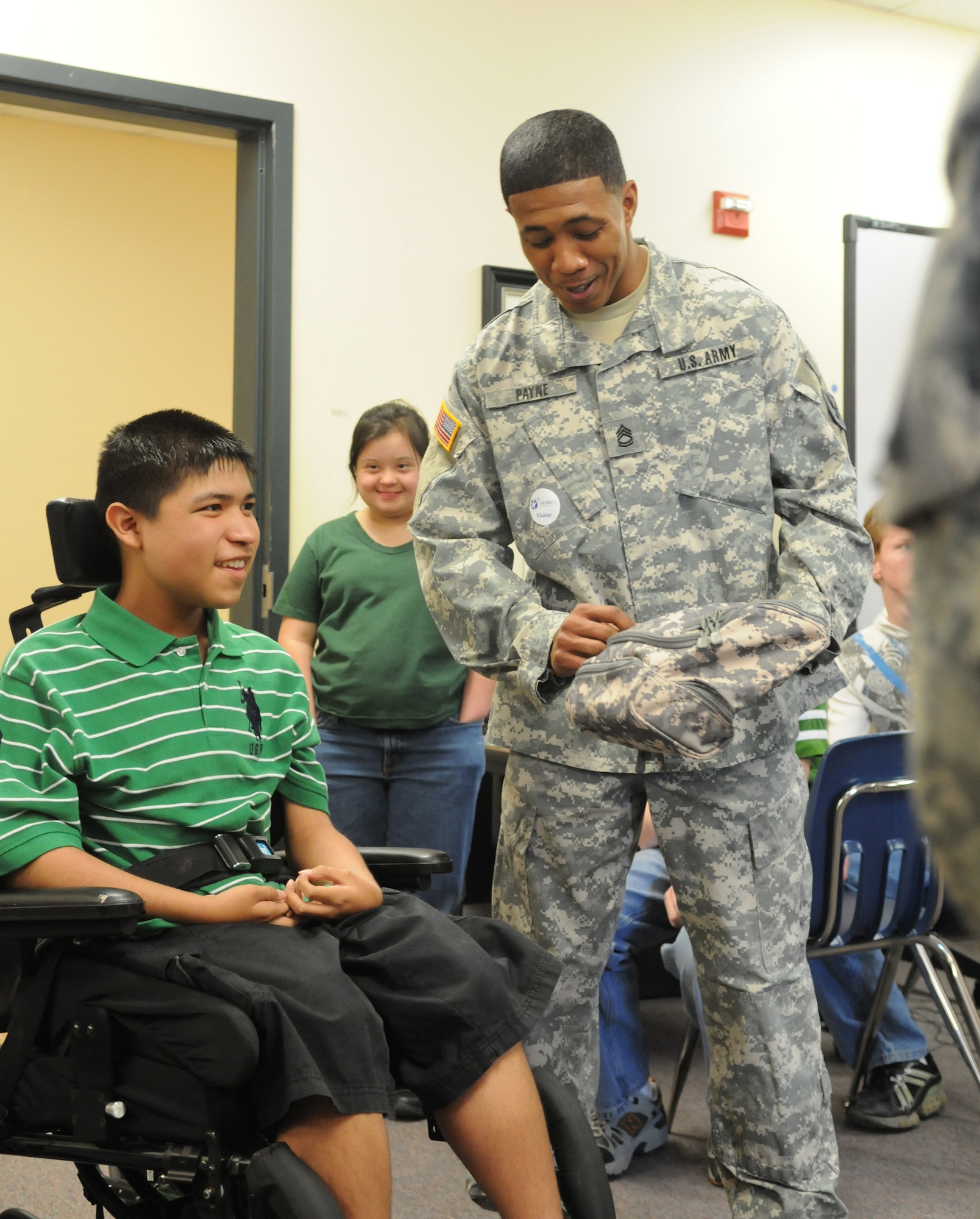SAN ANGELO, Texas -- Army Sgt. 1st Class Jason Payne presents Javier Aguirre an Army gift bag at Lincoln Junior High School, March 23, 2010. Javier has Duchere Muscular Dystrophy and expressed a wish, through the Make-A-Wish Foundation, to meet with U.S. Army Soldiers. Sgt. 1st Class Payne and fellow Soldiers from the 344th Military Intelligence Battalion, Goodfellow Air Force Base, answered the call. (U.S. Air Force photo/Airman 1st Class Clayton Lenhardt)