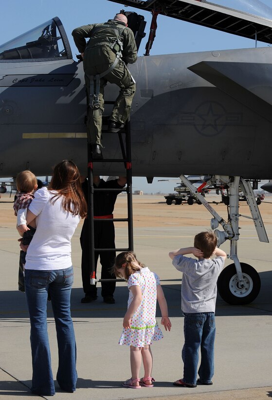 LANGLEY AIR FORCE BASE, Va. -- Maj. Brian Biebel, 71st Fighter Squadron pilot, climbs down an F-15C to greet his wife, Mandy, and children Connor, 5, Kaitlyn, 3, and Jack, 1, during his homecoming March 20. Ten F-15C Eagles from the 71st FS joined aircraft and personnel from five other bases to take part in a two week exercise called FANG Flag in Savannah, Ga. (U.S. Air Force photo/Airman Rebecca Montez)
