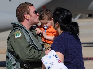 LANGLEY AIR FORCE BASE, Va. -- Capt. Timothy Dunagan, 71st Fighter Squadron pilot, greets his wife, Brooke, and son Teague, 1, during his homecoming March 20. Ten F-15C Eagles from the 71st FS joined aircraft and personnel from five other bases to take part in a two week exercise called FANG Flag in Savannah, Ga. (U.S. Air Force photo/Airman Rebecca Montez)