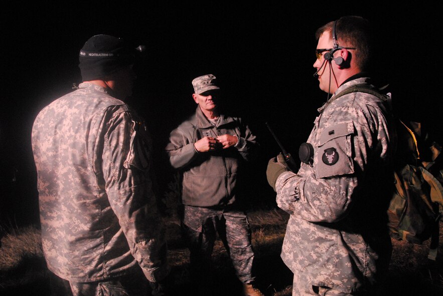 Minn. Army National Guard Capt. Cochrane (left), 34th ID, 2-135 Battalion, Alpha Company Commanding Officer, communicates with the Adjutant General of the North Dakota National Guard, Maj. Gen. David Sprynczynatyk (center) as Specialist Grandell looks on, during operations to slow the flow of water that is quickly eroding emergency spillway at Lake LaMoure, near LaMoure, N.D. on April 16, 2009.   310 members of the Minn. National Guard were deployed to eastern North Dakota under an Emergency Management Assistance Compact (EMAC) to provide assistance to civil authorities to support flood fighting operations.  This is the first time the Minnesota National Guard has deployed to North Dakota under this mutual aid compact.  (U.S. Air Force photo by Tech. Sgt. Brett R. Ewald)