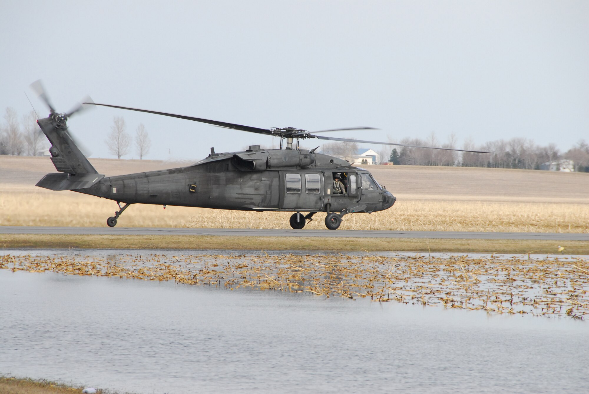 A UH-60 Blackhawk helicopter, of the North Dakota Army National Guard, 2-285 Assault Battalion, of Bismarck, N.D., lifts off from a landing strip in LaMoure, N.D while continuing on a mission to alleviate the flow of water over an eroding emergency spillway at nearby Lake LaMoure on April 16, 2009.   310 members of the Minn. National Guard were deployed to eastern North Dakota under an Emergency Management Assistance Compact (EMAC) to provide assistance to civil authorities to support flood fighting operations.  This is the first time the Minnesota National Guard has deployed to North Dakota under this mutual aid compact.  (U.S. Air Force photo by Tech. Sgt. Brett R. Ewald)
