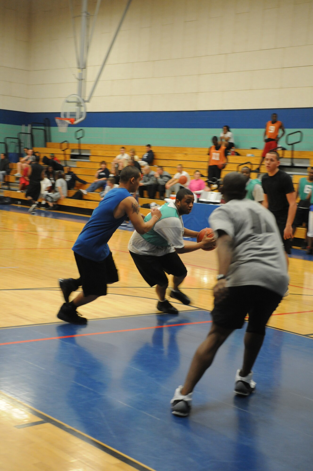 GOODFELLOW AIR FORCE BASE, Texas -- Airman 1st Class Corey Pasley, 17th Medical Group, runs the ball down the middle as Army Pfcs. Avery Mose and Brian Makaiati, 344th Military Intelligence Battalion, attempt to block during the bases 3 on 3 basketball tourney, March 20, 2010. (U. S. Air Force photo/Airman 1st Class Clayton Lenhardt)