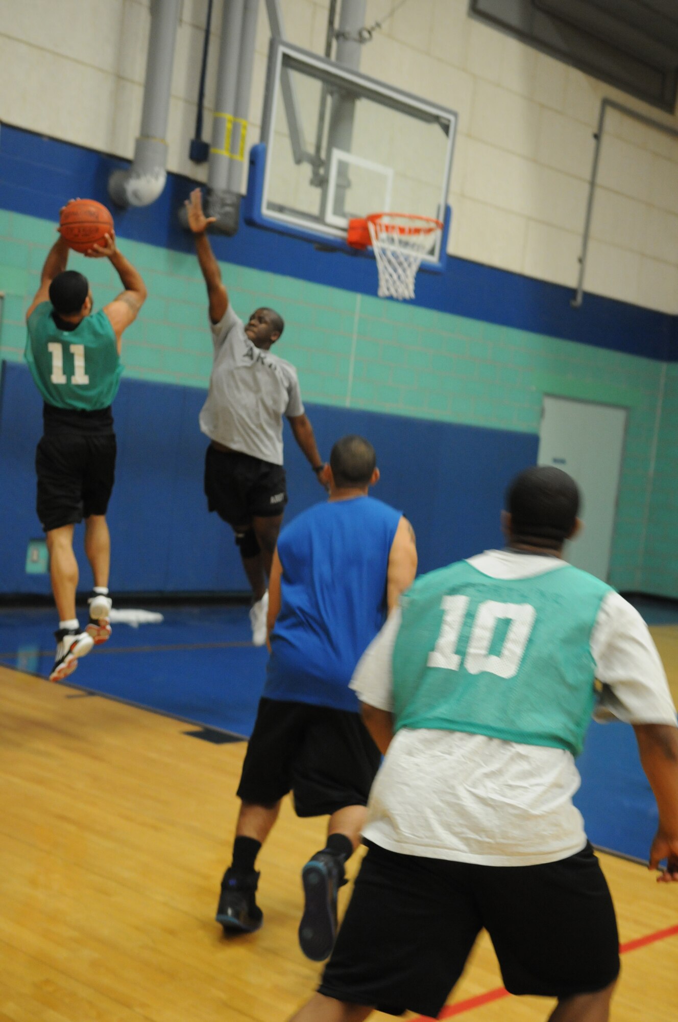 GOODFELLOW AIR FORCE BASE, Texas -- Tech. Sgt. Tim Harris, 316th Training Squadron, shoots as Army Pfc. Avery Mose, 344th Military Intelligence Battalion, attempts to block during the bases 3 on 3 basketball tourney, March 20, 2010. (U. S. Air Force photo/Airman 1st Class Clayton Lenhardt)