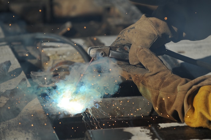 U.S. Air Force Master Sgt. Daniel Martin welds steel onto a pop-up security barrier at the inbound Rivers Avenue gate entrance on Joint Base Charleston, S.C., March 23, 2010. Sergeant Martin was the gate to weld more steel to the barrier for reinforcement. Sergeant Martin is the NCO in charge of the structure shop with 628th Civil Engineer Squadron. (U.S. Air Force photo/James Bowman/released)