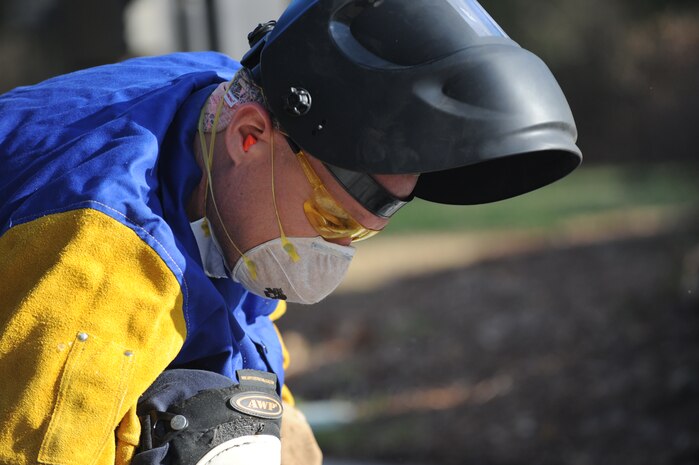 U.S. Air Force Master Sgt. Daniel Martin inspects the pop-up security barrier at the inbound Rivers Avenue gate entrance at Joint Base Charleston, S.C., March 23, 2010. Sergeant Martin was at the gate to weld more steel to the barrier for reinforcement. Sergeant Martin is the NCO in charge of the structure shop with 628th Civil Engineer Squadron. (U.S. Air Force photo/James Bowman/released)