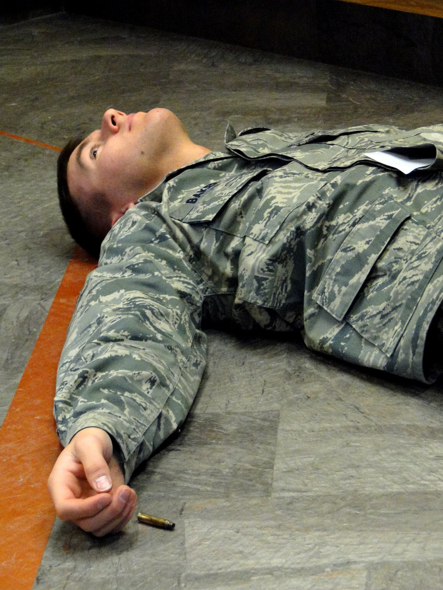 Airman 1st Class Justin Baker lies in wait of medical care March 22, 2010, Eielson Air Force Base, Alaska.  Airman Baker participated as a victim in an active shooter exercise during Eielson's Operational Readiness Exercise. Airman Baker is assigned to the 354th Contracting Squadron. (U.S. Air Force photo/Tech. Sgt. John Gott)