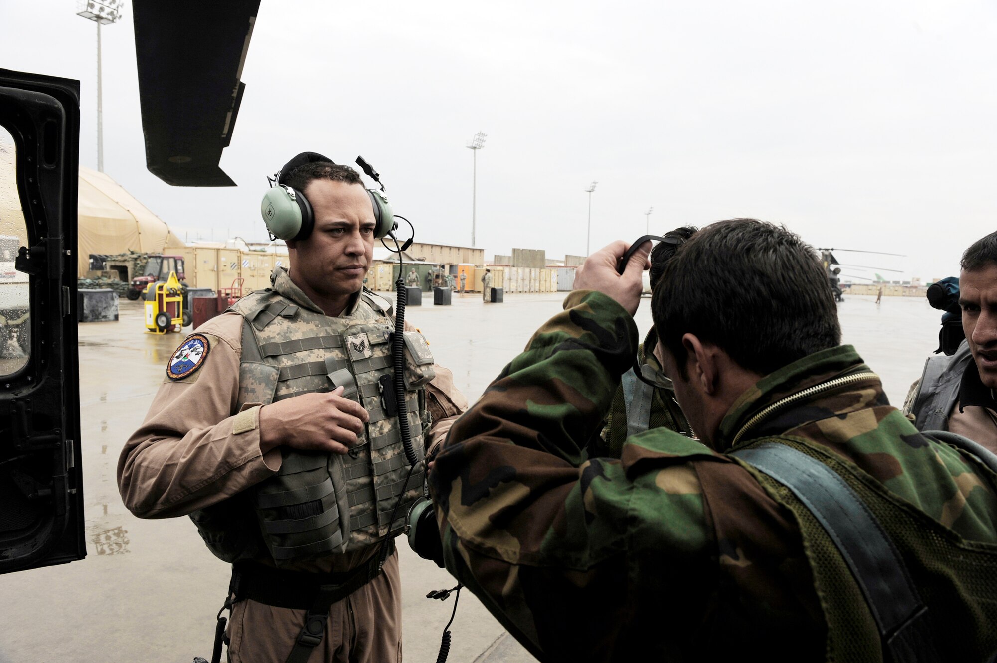 Tech. Sgt. Garrett Cain helps gear-up one of his Afghan National Army Air Corps crew chief students before boarding a UH-60 Blackhawk helicopter, Feb. 28, 2010, at Bagram Airfield, Afghanistan. Sergeant Cain is a rotary-wing crew chief mentor assigned to 440th Air Expeditionary Advisor Squadron. (U.S. Air Force photo/Staff Sgt. Manuel J. Martinez)