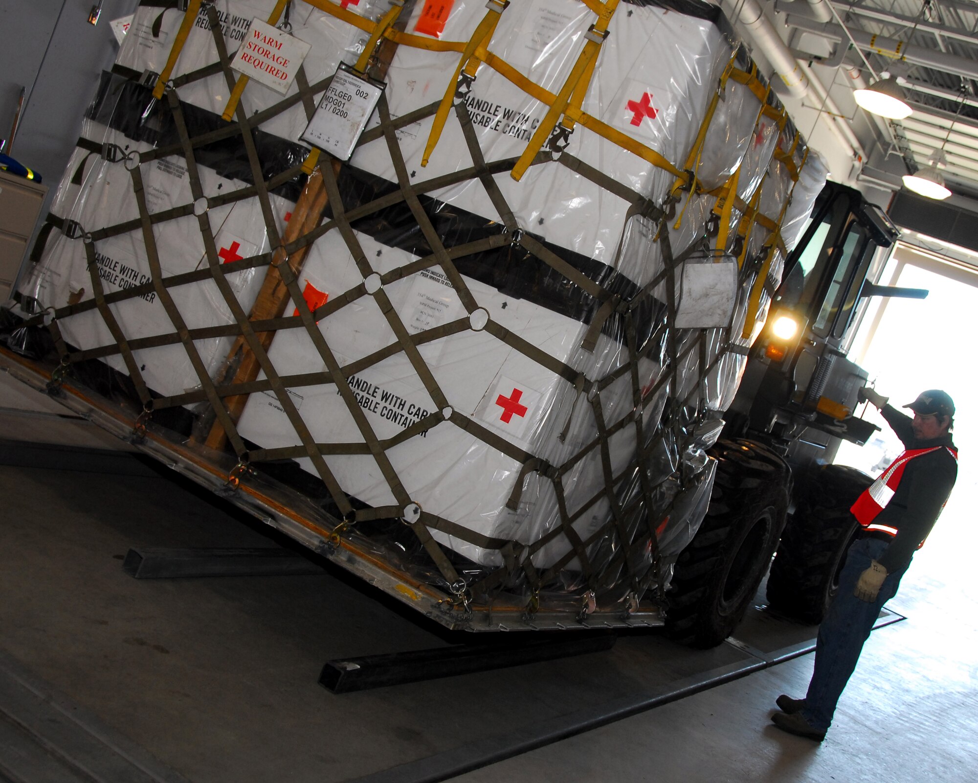 Todd Lien directs the a forklift driver to lower a pallet for inspection during an Operational Readiness Exercise March 21, 2010, Eielson Air Force Base, Alaska.  Mr. Lien is a pallet inspector with the 354th Logisitics Readiness Squadron. (U.S. Air Force photo/Staff Sgt. James Stewart)
