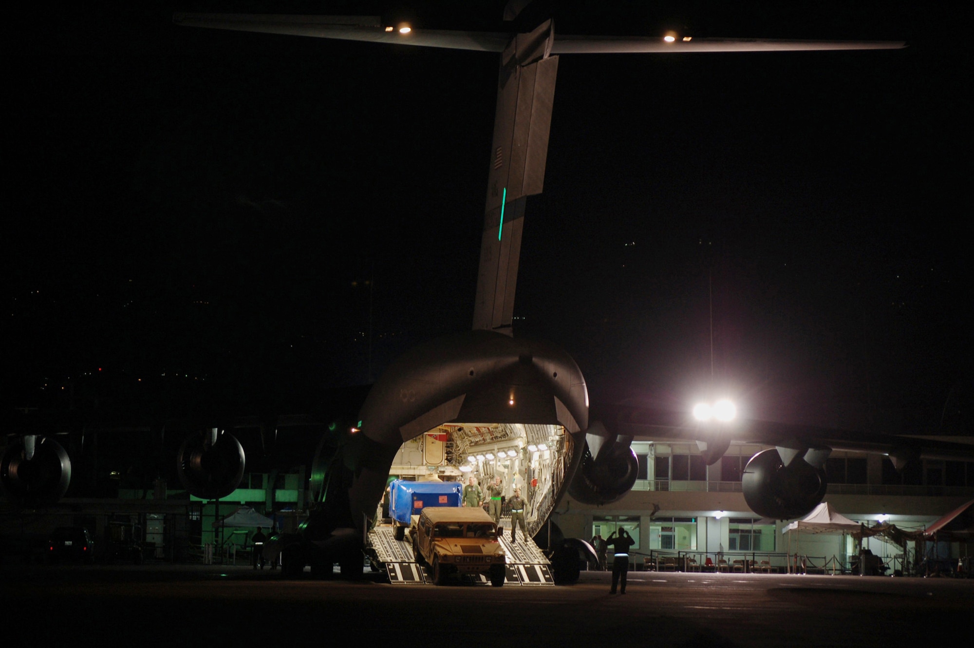 Mobility Airmen assigned to the 621st Contingency Response Wing from Joint Base McGuire-Dix-Lakehurst, N.J. unload relief supplies from a C-17 Globemaster III at Toussaint Louverture International Airport Jan. 28, 2010, in Port-au-Prince, Haiti. The wing provided airfield operations expertise in the aftermath of a 7.0 magnitude earthquake that crumbled most of the surrounding area, killing hundreds of thousands and displacing millions from their homes. (U.S. Air Force photo/Tech. Sgt. Matthew Loy)