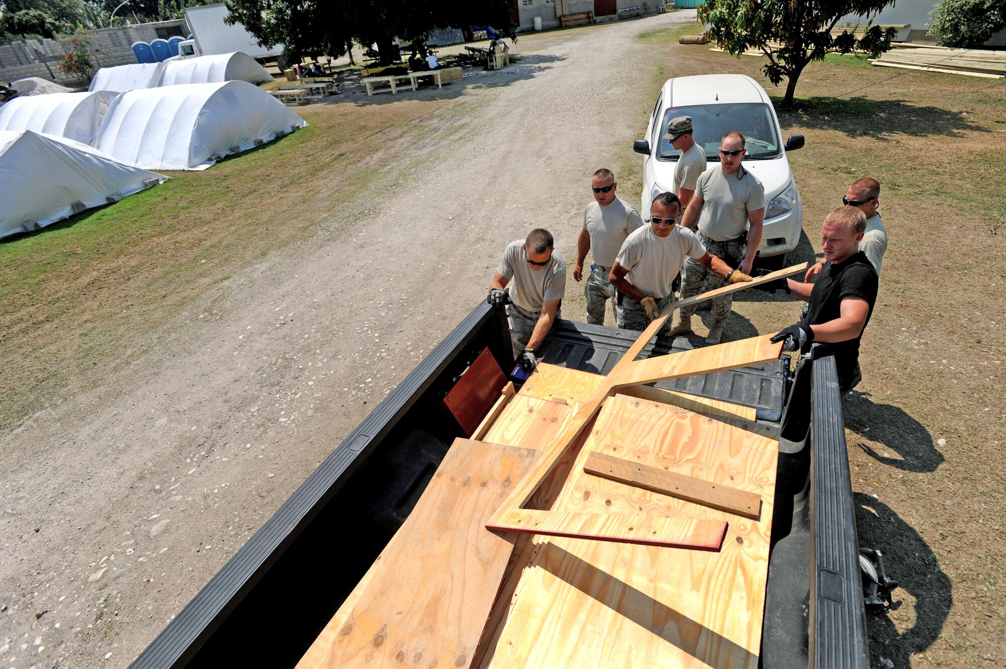 Members of the 118th Civil Engineering Squadron remove lumber from the back of a truck as they begin work on various construction projects at the New Life Children's Home in Port au Prince, Haiti, Friday, March 12, 2010. Members of the squadron have been working at the home, a local orphanage that has also taken in many children injured by the January earthquake, building cabinets, storage areas and a medical clinic.(U.S. Army photo by Sgt. 1st Class Jon Soucy)(Released)
