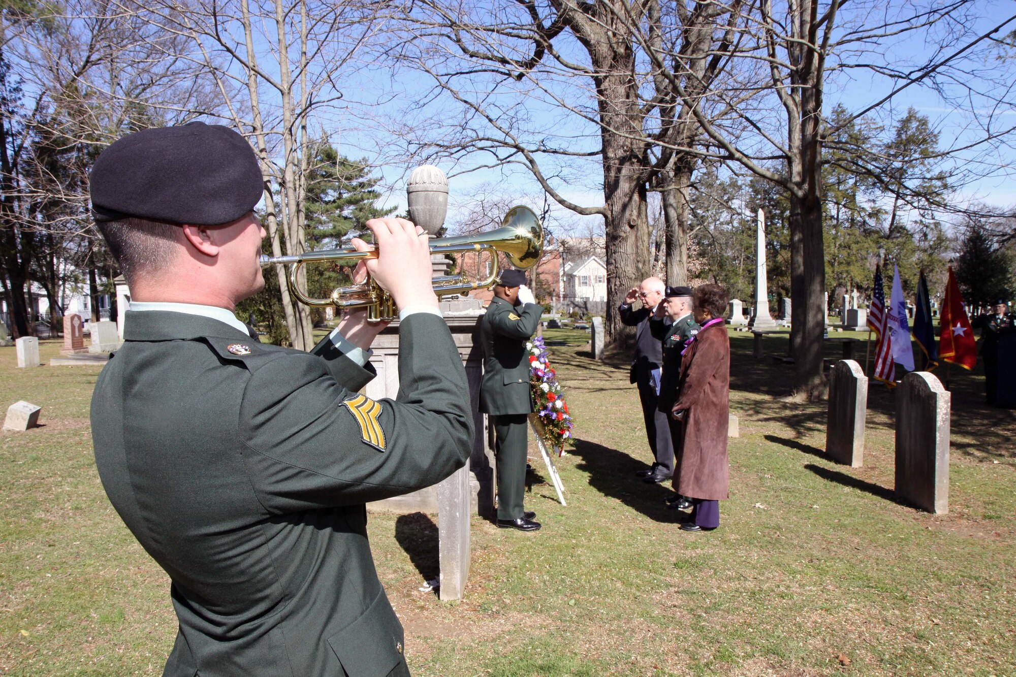 Sgt. Matthew Belcher from the 78th Army Band plays "Taps" as Mildred T. Trotman, mayor of Princeton Borough (left); Bernard P. Miller, mayor of Princeton Township(right) and Maj. Gen William Monk III, commanding general, 99th Regional Support Command (center) render honors during the Grover Cleveland Presidential Wreath Laying Ceremony at Princeton Cemetery March 18. The White House Military Office is responsible for coordinating the annual placement of Presidential Wreaths at tombs and resting places of former presidents, other famous Americans and at certain memorials of historical significance. (U.S. Army photo/Staff Sgt. Alyn-Michael Macleod)

