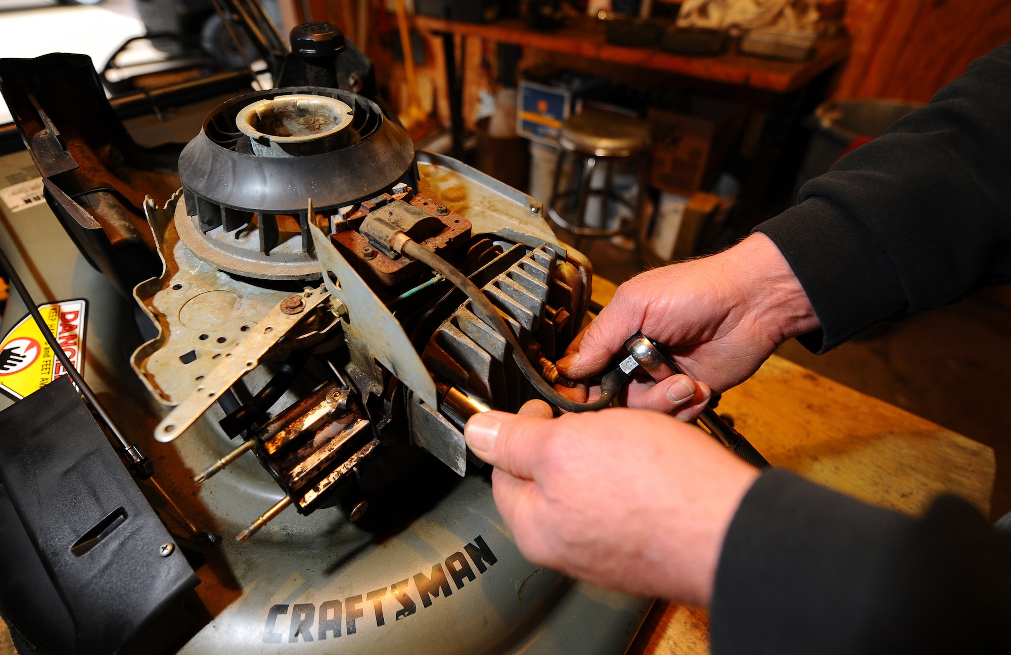 OFFUTT AIR FORCE BASE, Neb. -- Rocky Rengo, an Equipment Rental assistant, changes a spark plug as part of routine and seasonal maintenance on a lawnmower at the Equipment Rental facility, located on Butler Boulevard March 19. Equipment Rental offers a wide array of items for recreational use and yard maintenance, as well as a small machine shop that services most small motor items. U.S. Air Force photo by Josh Plueger
