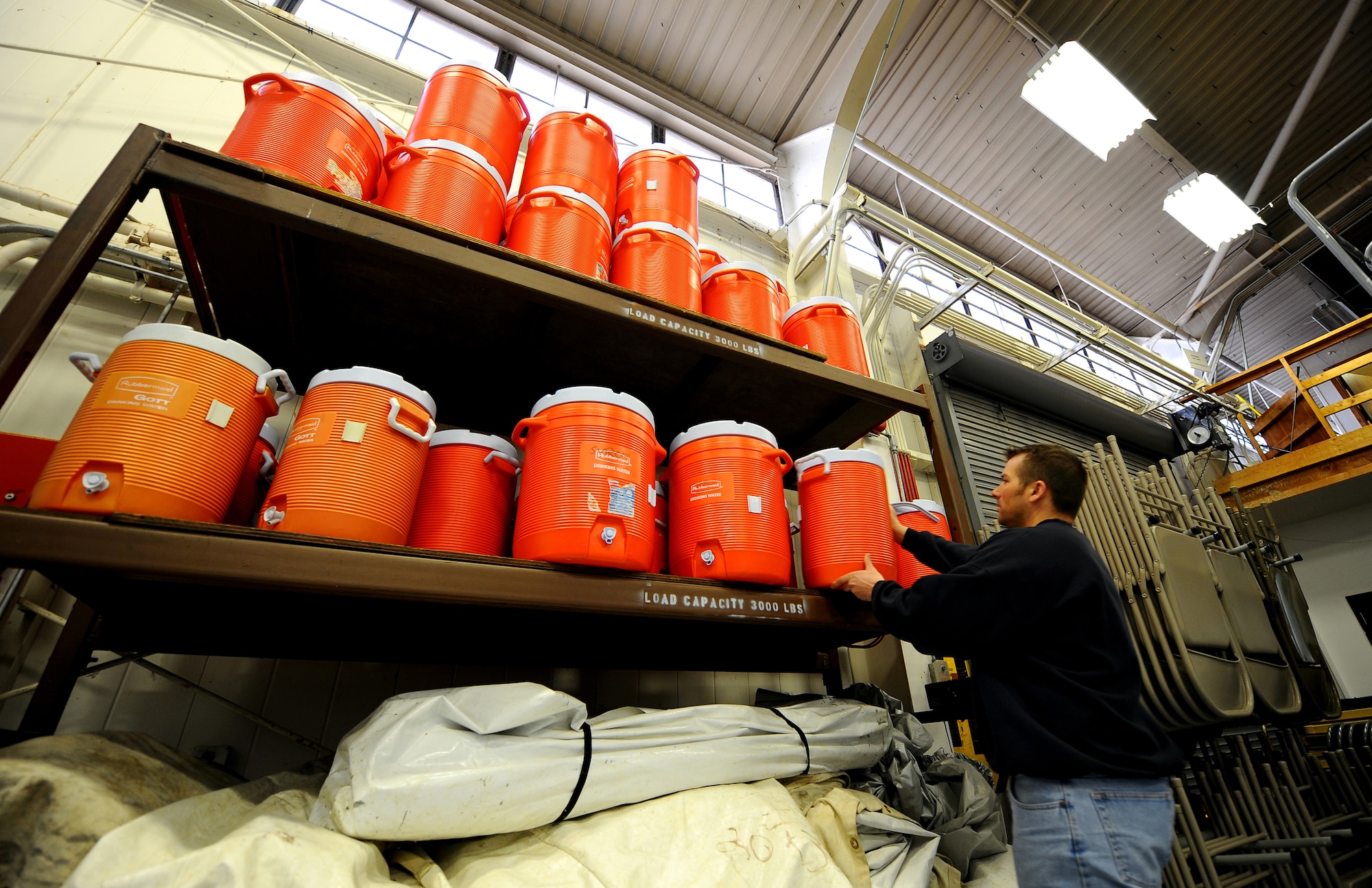 OFFUTT AIR FORCE BASE, Neb. -- Jay Ehlers, Equipment Rental manager, stacks water coolers on a shelf that can be rented from the Equipment Rental Office, located on Butler Boulevard March 19.  Equipment Rental offers a wide array of items for recreational use and yard maintenance, as well as a small machine shop that services most small motor items. U.S. Air Force photo by Josh Plueger
