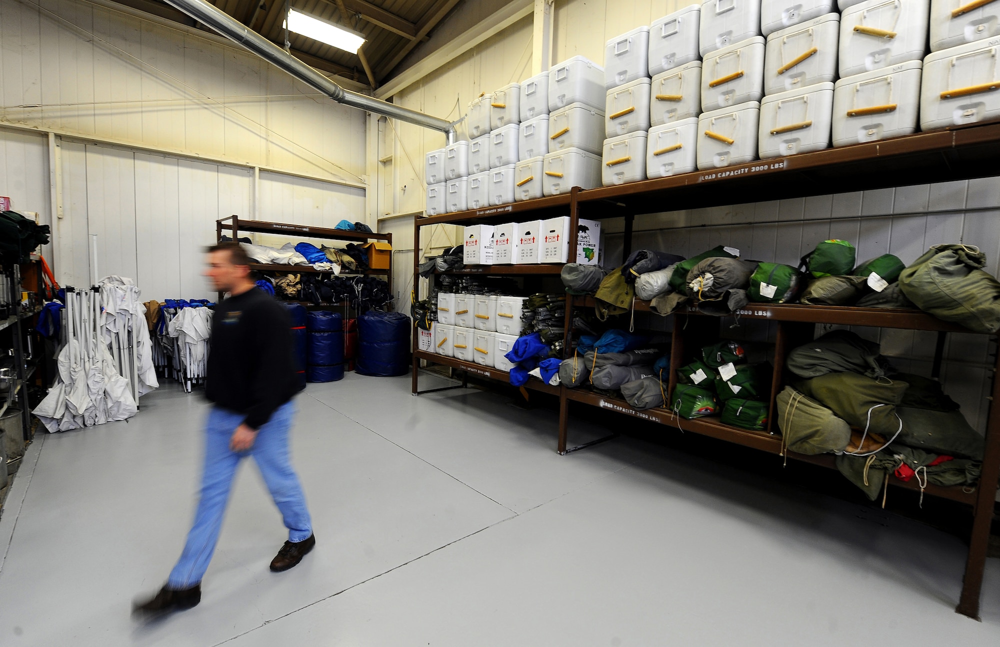 OFFUTT AIR FORCE BASE, Neb. -- Jay Ehlers, Equipment Rental manager, walks away from a wall of shelves March 19 containing air compressors, tents and coolers which is but a few of the items that can be rented from the Equipments Rental facility, located on Butler Boulevard. Equipment Rental offers a wide array of items for recreational use and yard maintenance. U.S. Air Force photo by Josh Plueger

